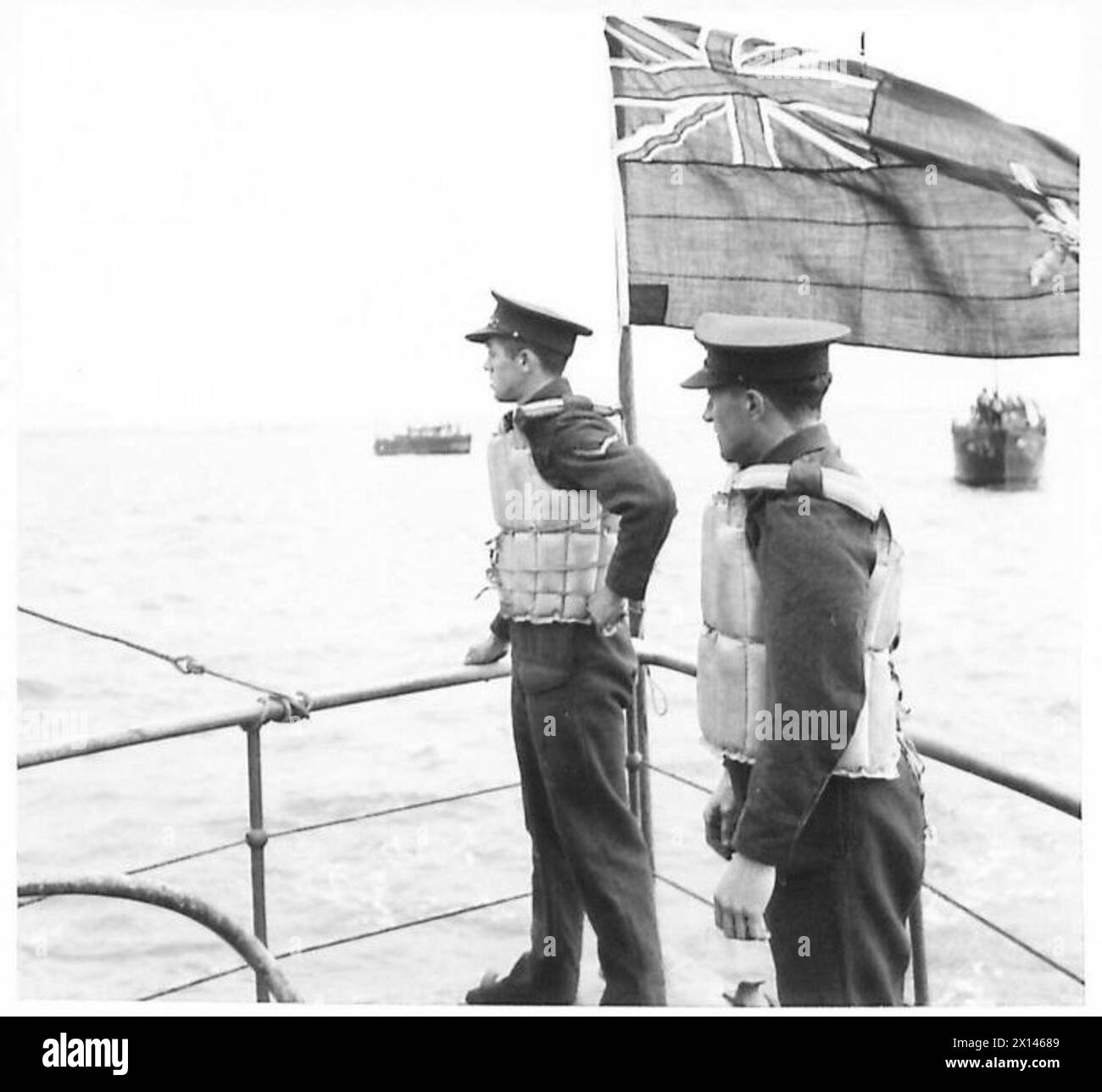 Deux membres d'équipage gardent le guet lorsqu'une flottille part, mettant en valeur la coordination entre l'armée et la marine. Banque D'Images