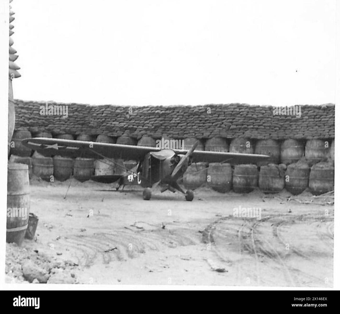 Un avion d'observation d'artillerie est stationné dans une baie à l'épreuve des explosions sur la piste d'atterrissage d'Anzio, illustrant les opérations de la RAF et la sécurité de l'aérodrome. Banque D'Images