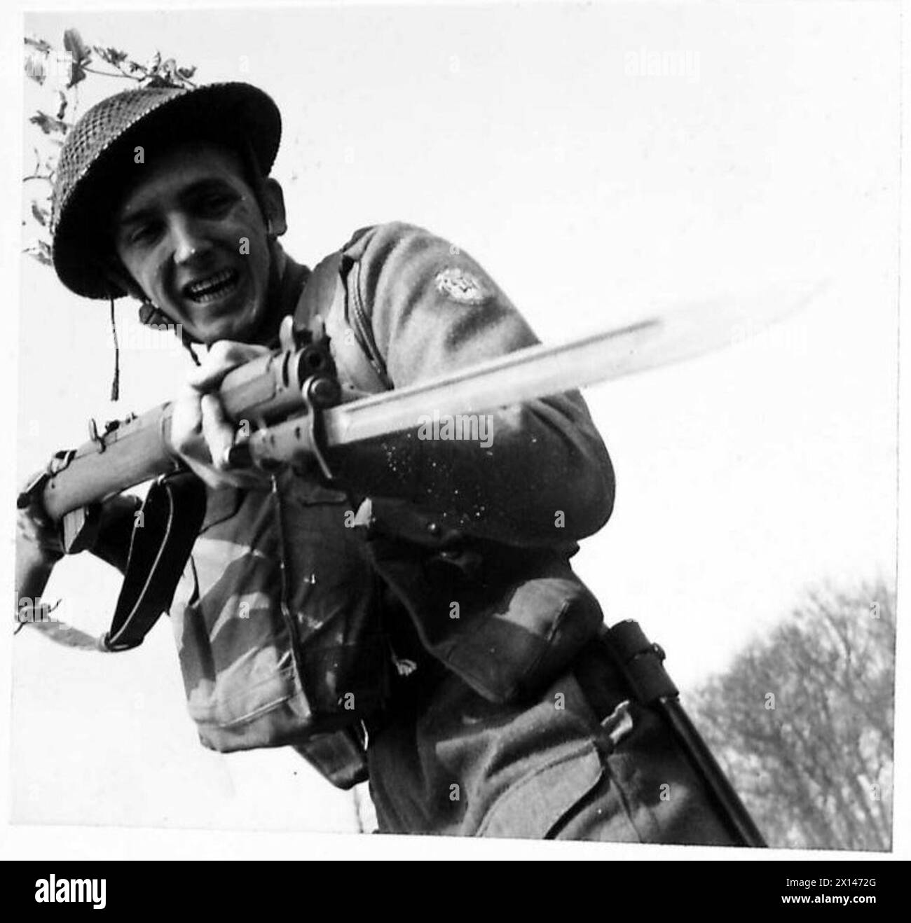 Un infanterie s'échappe d'un parapet de tranchée, démontrant des manœuvres offensives et de l'esprit pendant les opérations de l'armée britannique. Banque D'Images