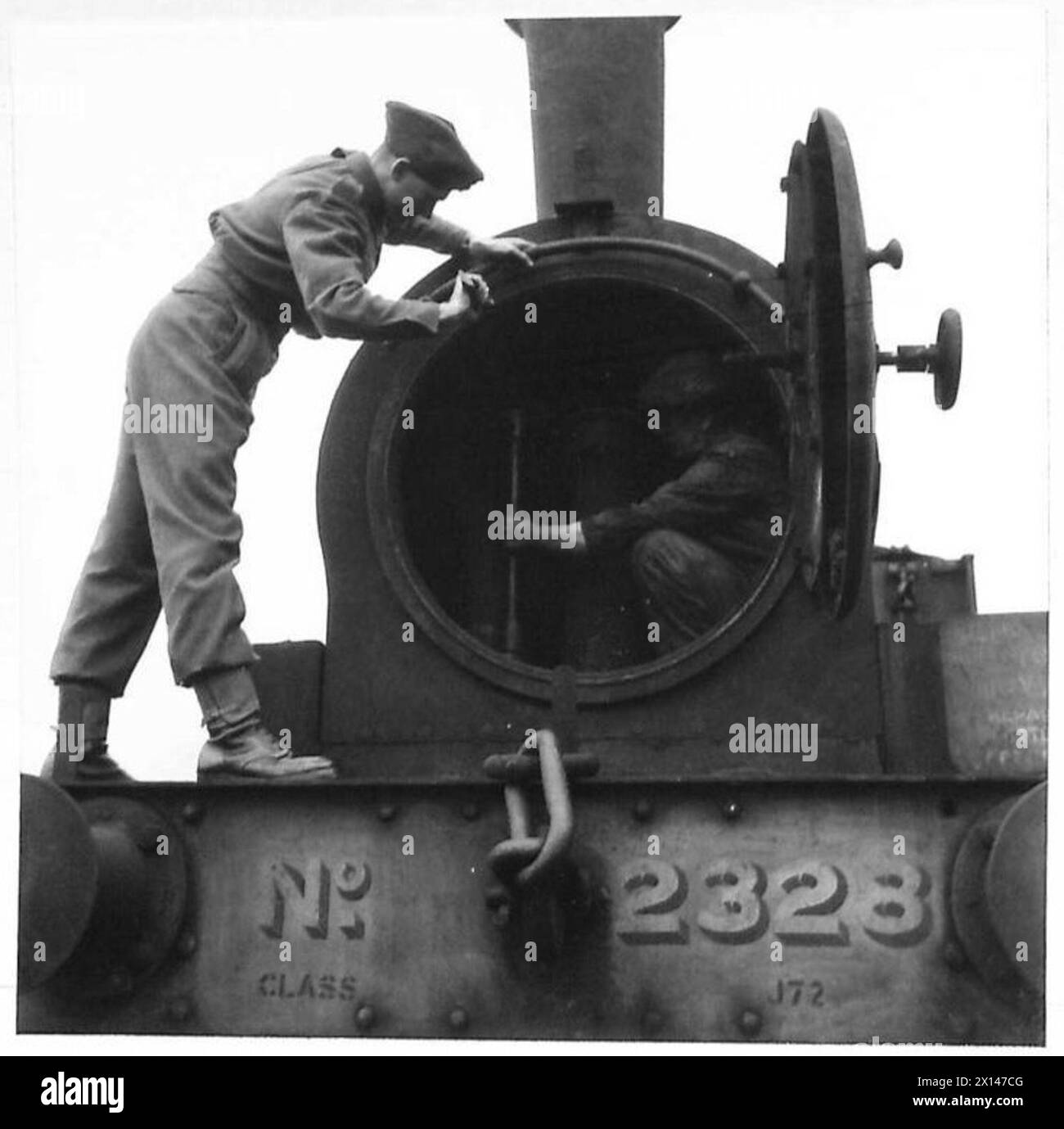 Un sapeur Royal Engineers aide un installateur ferroviaire à retirer la conduite de vapeur principale d'une boîte à fumée de locomotive pendant la formation sur l'exploitation ferroviaire. Banque D'Images