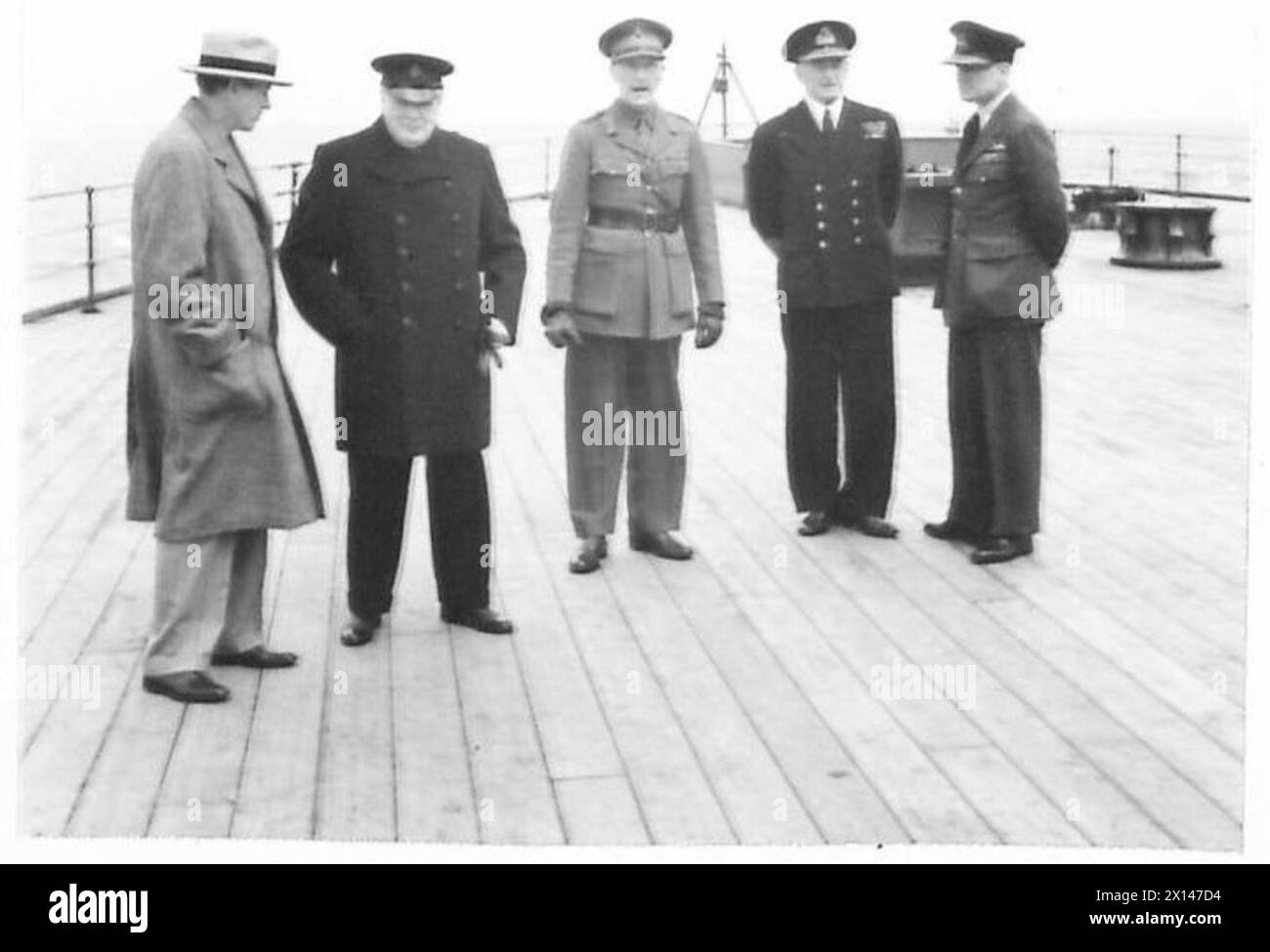 Le premier ministre Harry Hopkins, le général Sir John Dill, l'amiral Sir Dudley Pound et le maréchal en chef de l'air Sir Wilfred Freeman traversent l'Atlantique à bord du HMS Prince of Wales pour rencontrer le président Roosevelt, observé par le personnel de l'armée britannique. Banque D'Images