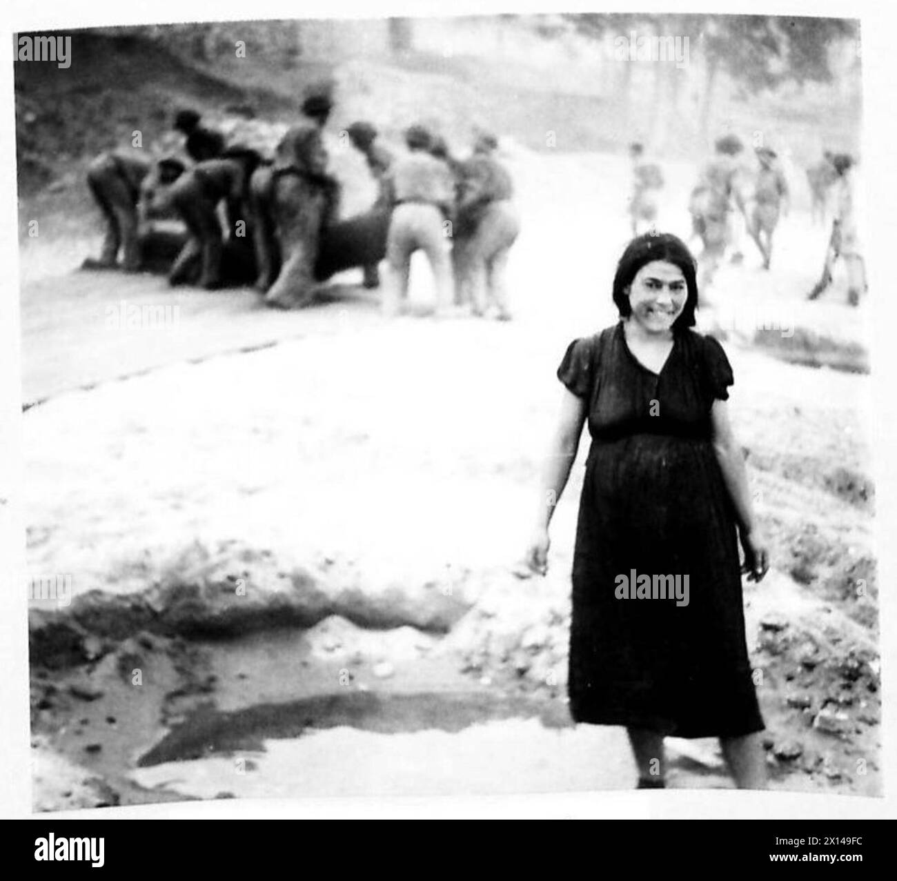 Une italienne observe le déchargement de véhicules et de matériel militaires sur la plage pendant l'invasion alliée de l'Italie. Banque D'Images