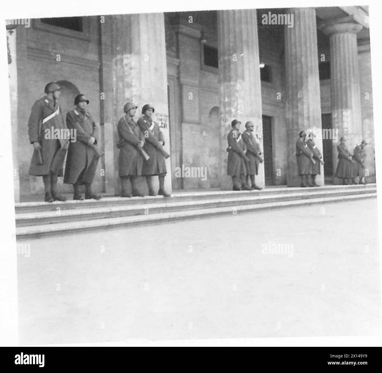 Des gardes italiens sont stationnés devant l'entrée du théâtre lors d'une réunion du Front de libération nationale, observée par le personnel de l'armée britannique. Banque D'Images