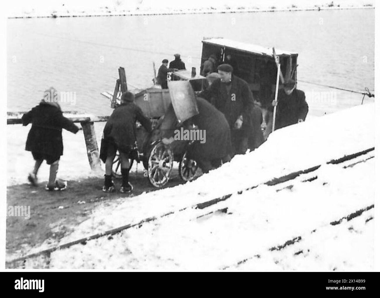 Des civils évacuent un village en conduisant des charrettes chargées sur un ferry, British Army, 21st Army Group. Banque D'Images