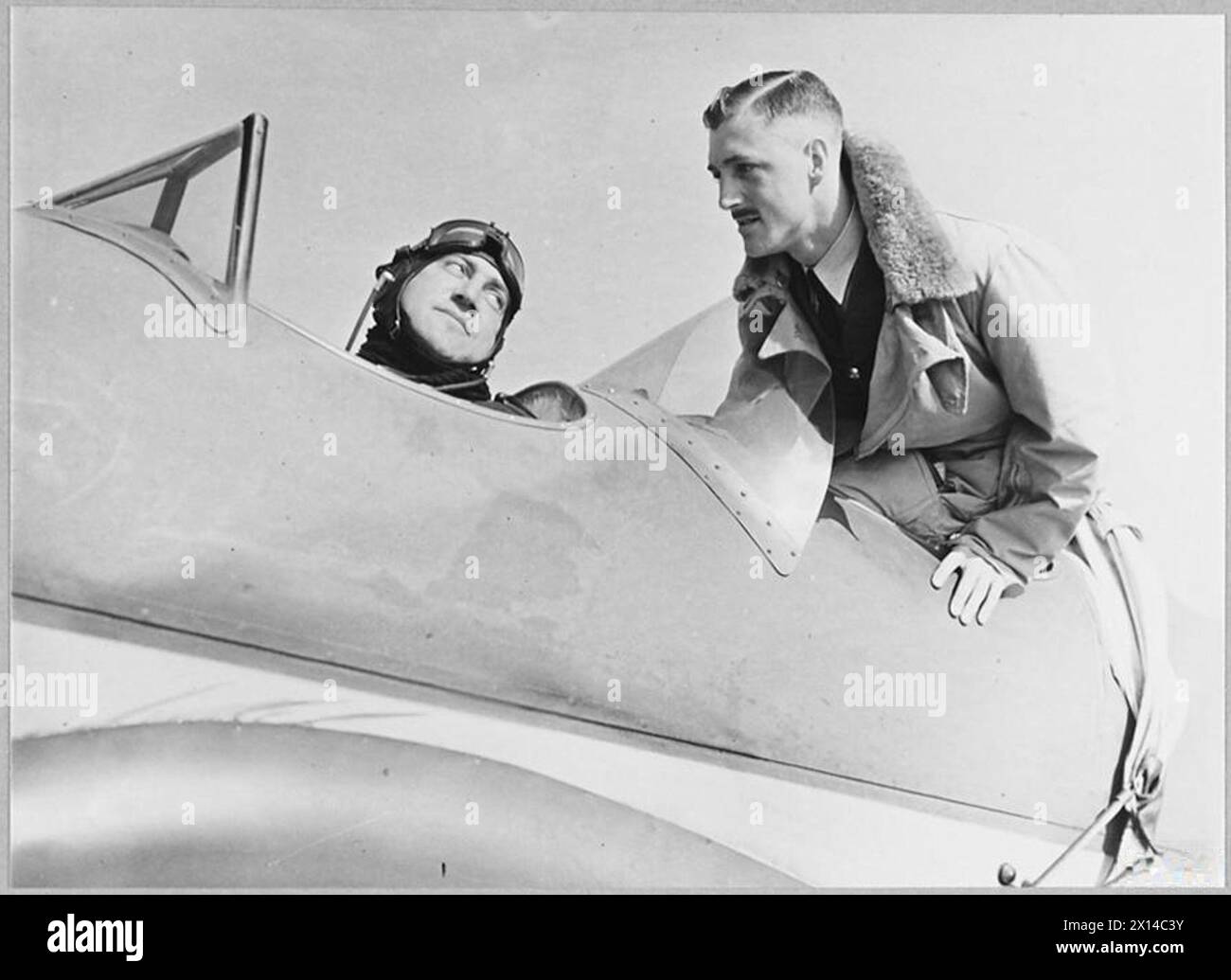 Instructeur fournit des mots de conseils et de félicitations aux pilotes stagiaires de la RAF, illustrant la formation opérationnelle et le mentorat. Banque D'Images