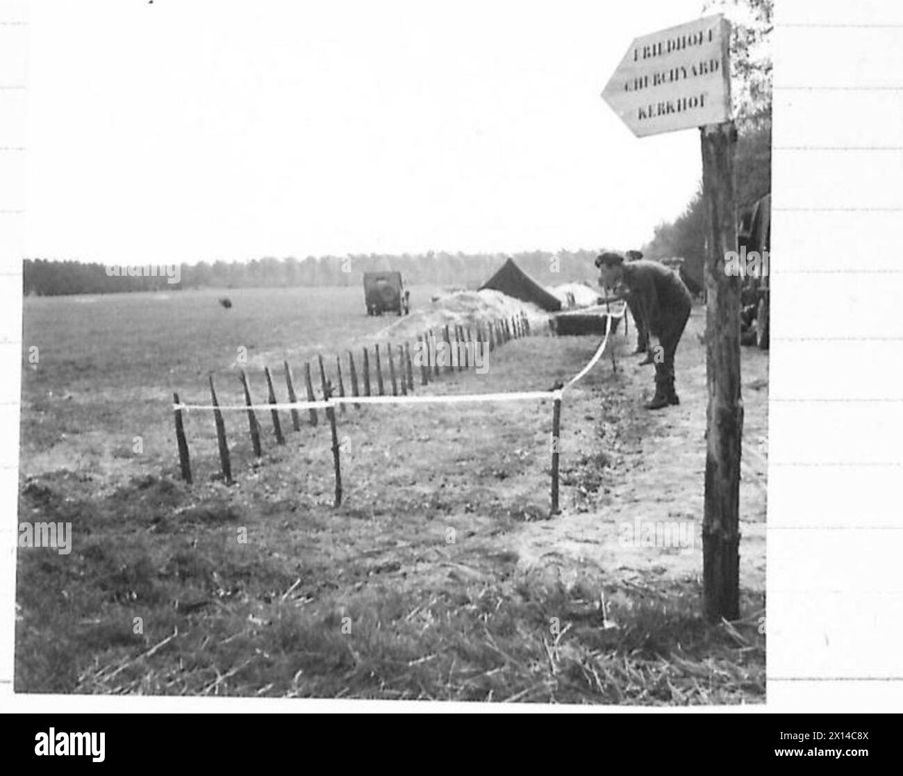 Photographie montrant des tombes en bord de route de soldats britanniques morts lors de la campagne de 1944-45 en Europe du Nord-Ouest à Arnhem, avec un panneau multilingue en anglais, néerlandais et allemand. Banque D'Images