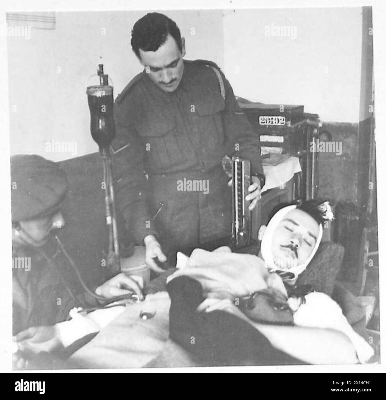 Le capitaine Sutton de la huitième armée britannique administre une transfusion sanguine à un civil italien grièvement blessé lors d'un raid aérien, dans le cadre d'une aide médicale d'urgence. Banque D'Images