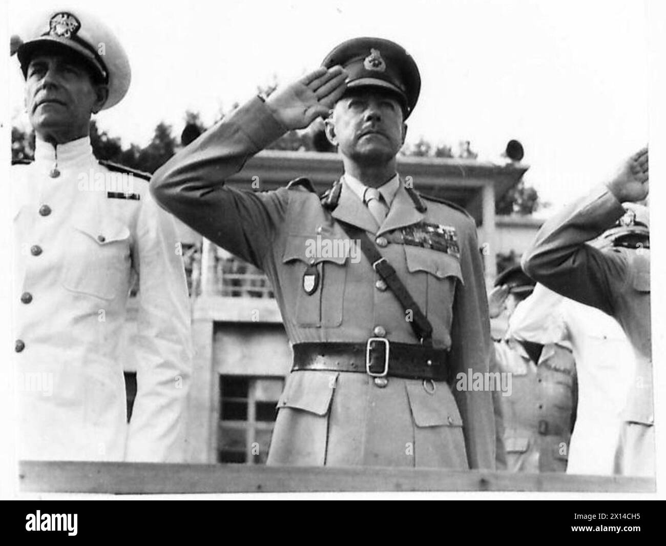 Le Field Marshal Alexander salue pendant le jeu de l'hymne national lors d'un service de Thanksgiving VJ tenu par l'AFHQ Banque D'Images