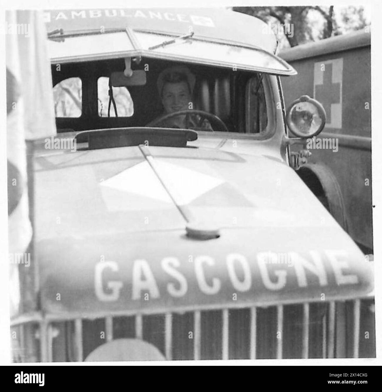 Jacqueline Becharp, une chauffeuse de la Croix-Rouge française de 20 ans, est assise au volant de son ambulance et porte un foulard en turban. Banque D'Images