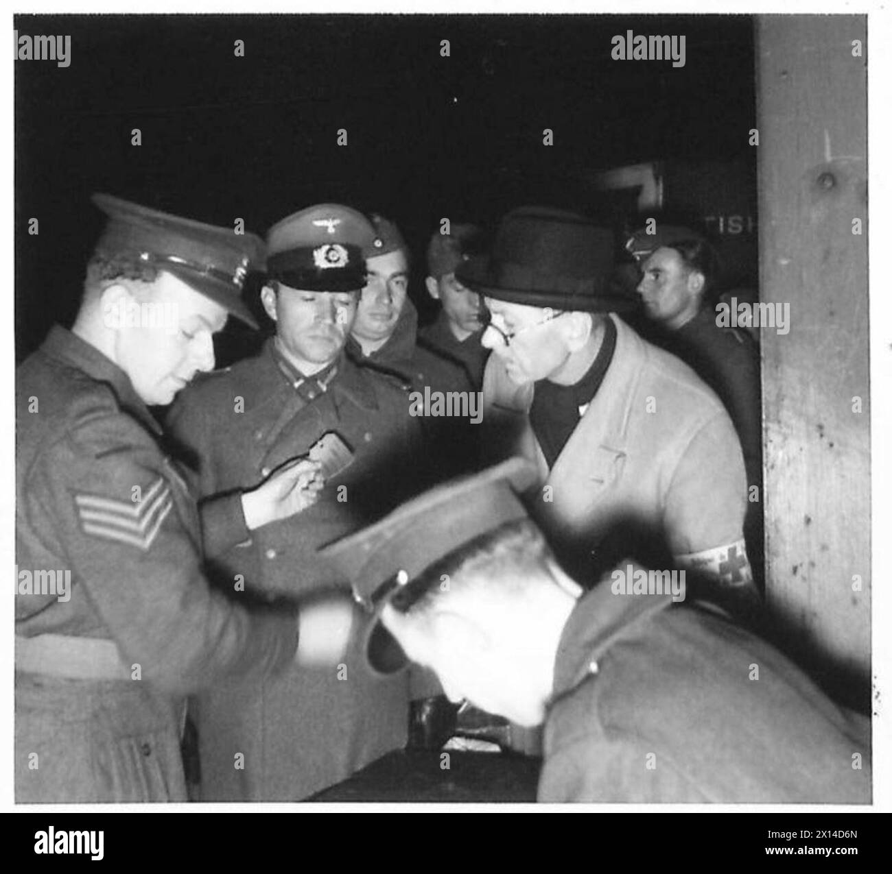 RAPATRIEMENT DES PRISONNIERS DE GUERRE ET INTERNÉS ALLEMANDS - soldats allemands s'enregistrant à la table de l'officier de sécurité avant l'embarquement. Sur la droite se trouve le délégué de l'armée britannique de la Croix-Rouge internationale Banque D'Images