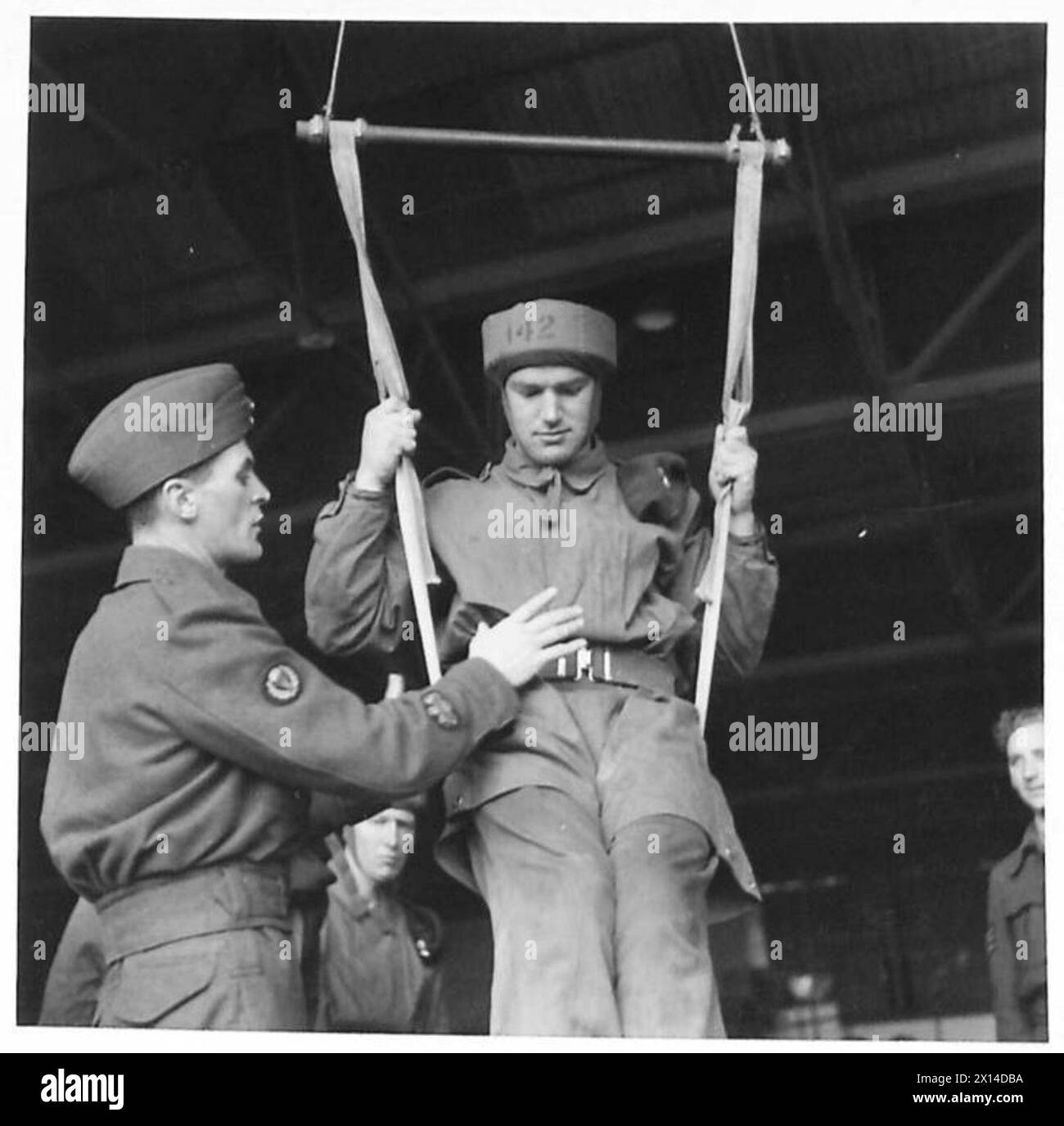 Les recrues de parachutistes utilisent des balançoires pour apprendre la position correcte des pieds et des genoux pendant un largage, guidées par un instructeur de la RAF. Banque D'Images