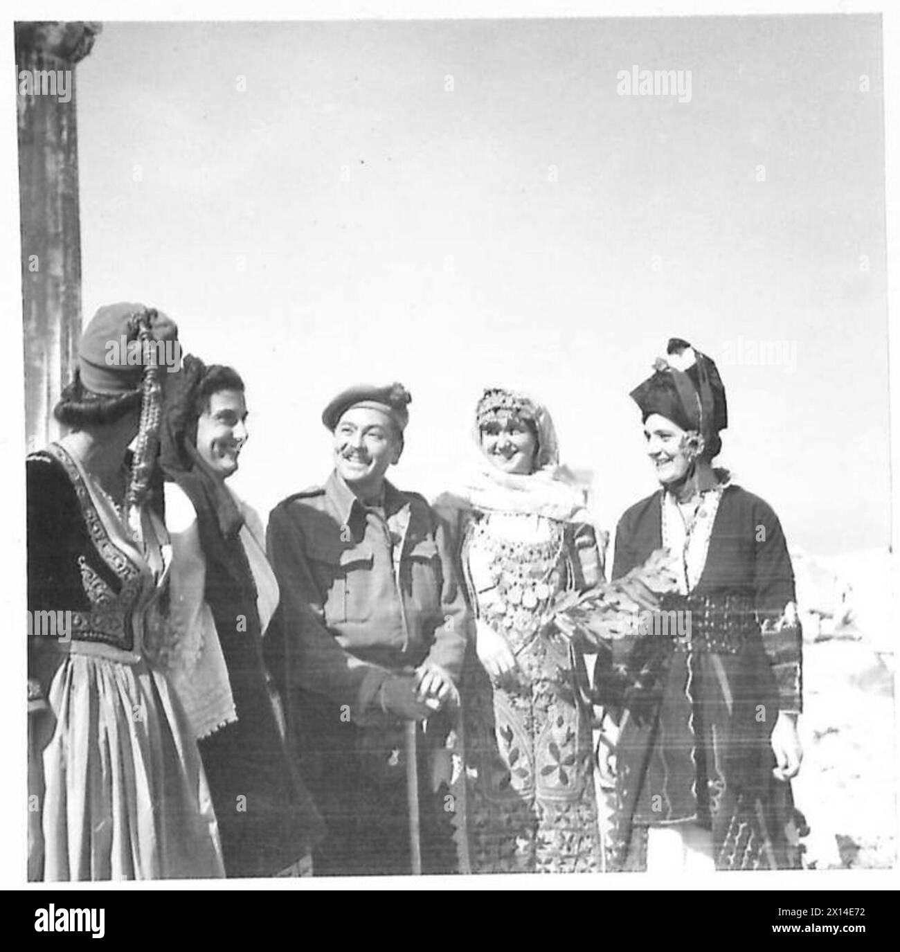 Un officier britannique est vu avec des filles grecques portant un costume national lors du retour du gouvernement grec en Grèce. Banque D'Images
