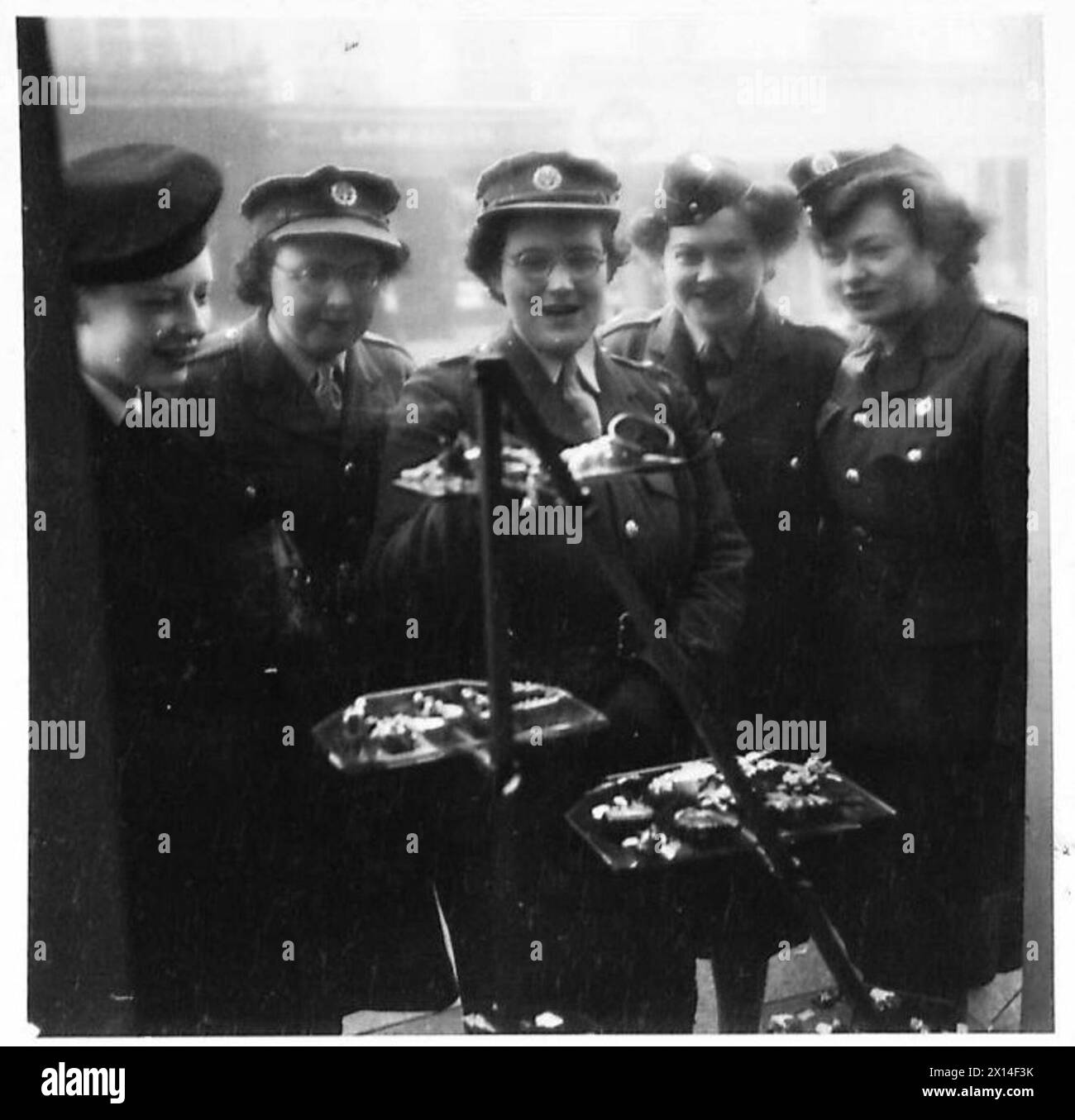 Des filles militaires du S.H.A.E.F. sont photographiées observant des blouses et des bijoux à travers une vitrine pendant leurs loisirs dans les zones de l'armée britannique. Banque D'Images