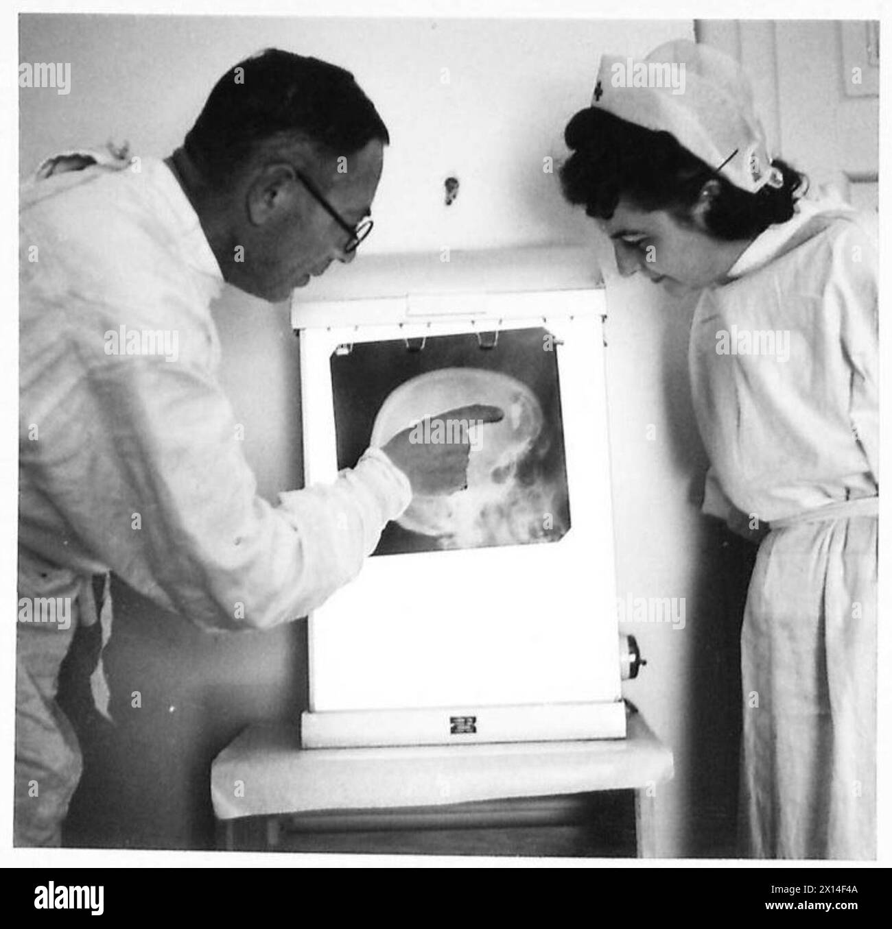 Dr Reznikov et sœur Jadwiga Reszczyńska examinent une radiographie montrant une fracture rare du crâne à l'hôpital de la Croix-Rouge polonaise à Téhéran. L'hôpital traite les patients polonais, britanniques et indiens à l'aide d'équipements de radiographie nouvellement installés financés par des sources polonaises. Banque D'Images