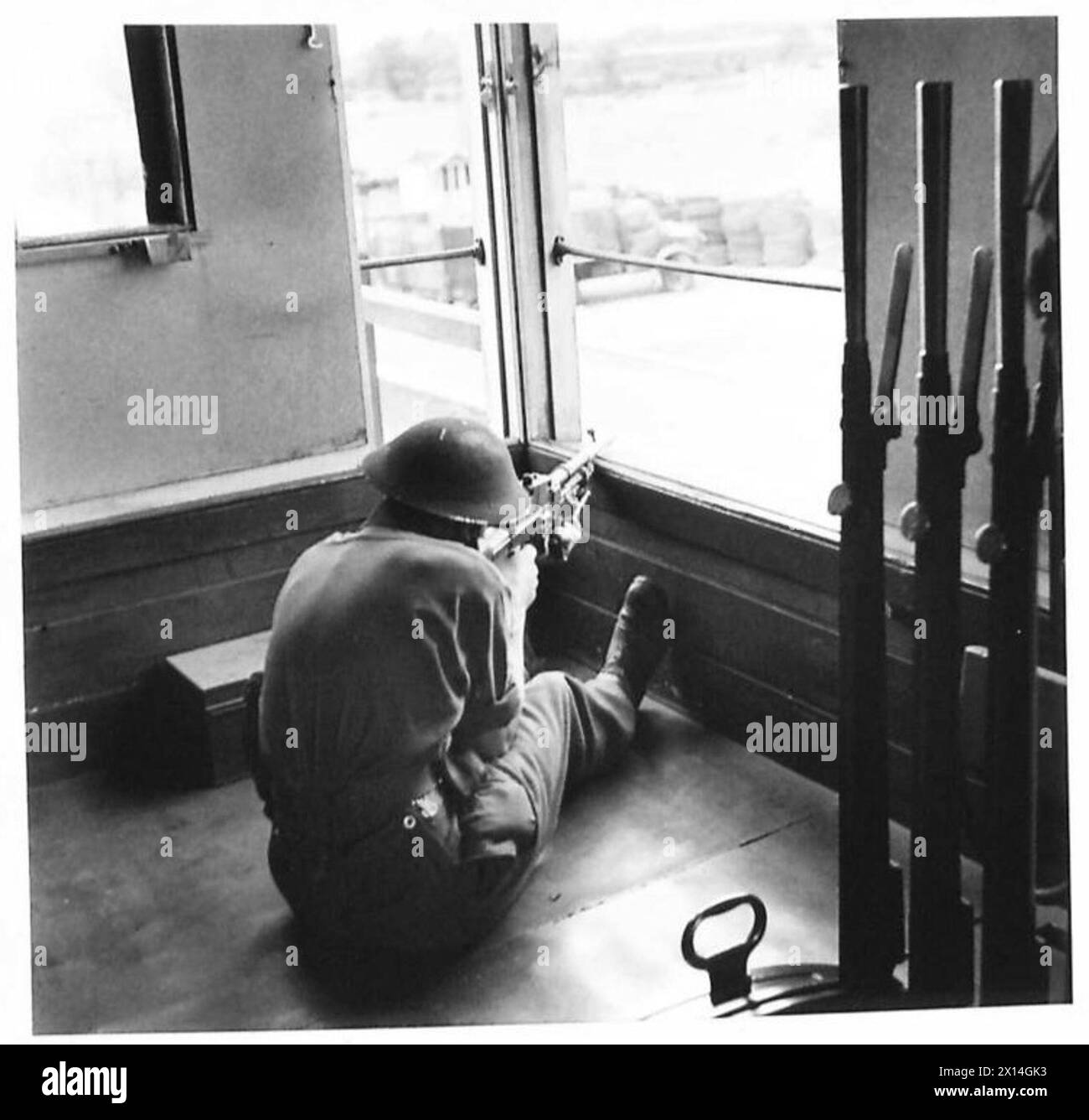 Un mitrailleur Bren fournit un feu couvrant au-dessus d'une gare ferroviaire à partir d'une boîte de signalisation pendant un exercice d'école de bataille. Banque D'Images