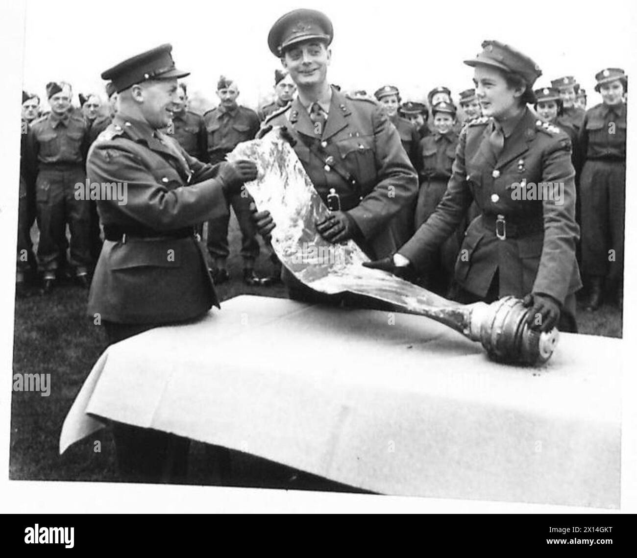 TROPHÉE DE LAME POUR LES ARTILLEURS - Brigadier W.H.G. Rogers, le commandant de brigade A.A. présentant la lame de l'hélice au Capitaine A.E. Standbrook [commandant du site] et au commandant junior P.R. Thomson [officier de complot] de l'Armée britannique Banque D'Images