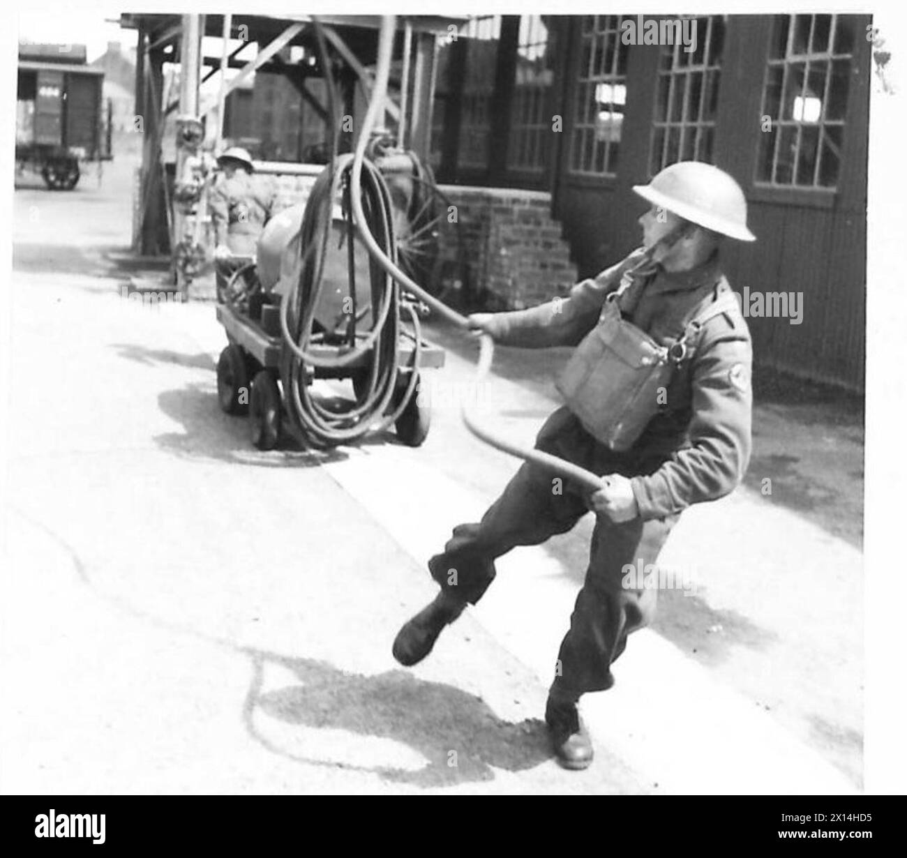Les pompiers de l'armée britannique utilisent un moteur à mousse sur les lieux d'un incendie ; un extincteur à mousse de 30-34 gallons est tenu en réserve pour les petits incendies. Banque D'Images