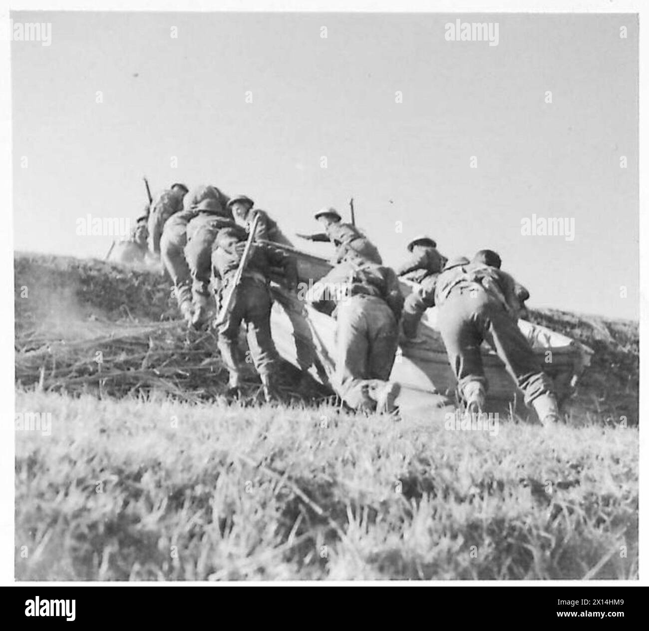Les fantassins de la 8e armée poussent des embarcations d'assaut sur une rive escarpée dans le cadre des préparatifs de l'offensive de printemps, démontrant des manœuvres de troupes et des opérations de franchissement de rivière. Banque D'Images