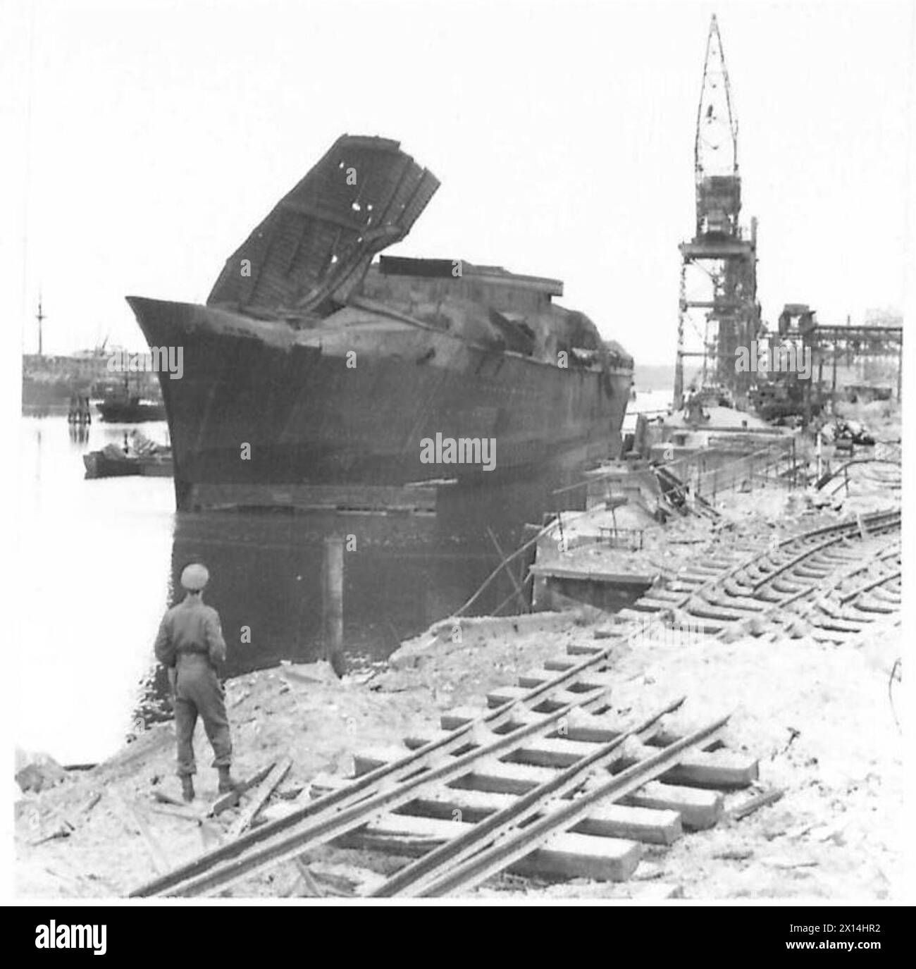 Un navire endommagé est montré sur les quais de Hambourg après la reddition, illustrant la destruction et les conditions post-combat sous le 21e groupe d'armées britannique. Banque D'Images