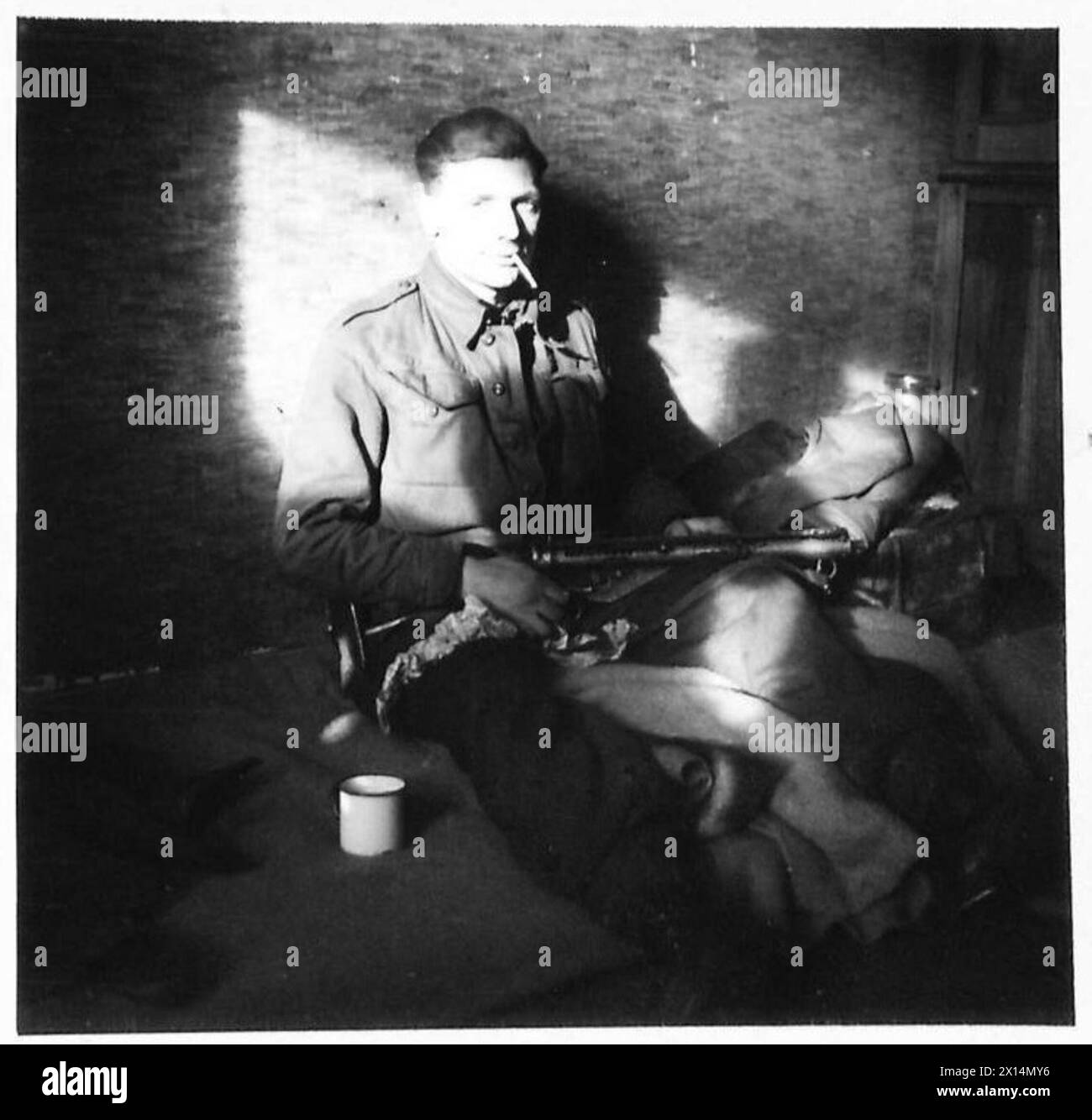 Le caporal D. Carlile d'Endworth, Birmingham repose au bord de la rivière Maas avant une patrouille de nuit pendant les opérations du jour J avec l'armée britannique, 21e groupe d'armées. Banque D'Images