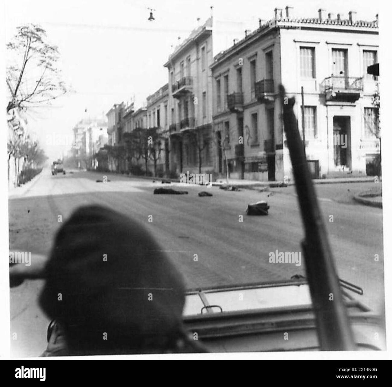 Une scène de la guerre civile grecque montre un carrefour en feu et les corps de policiers tués après l'évacuation par char, représentant un conflit impliquant les forces de l'E.L.A.S. Banque D'Images