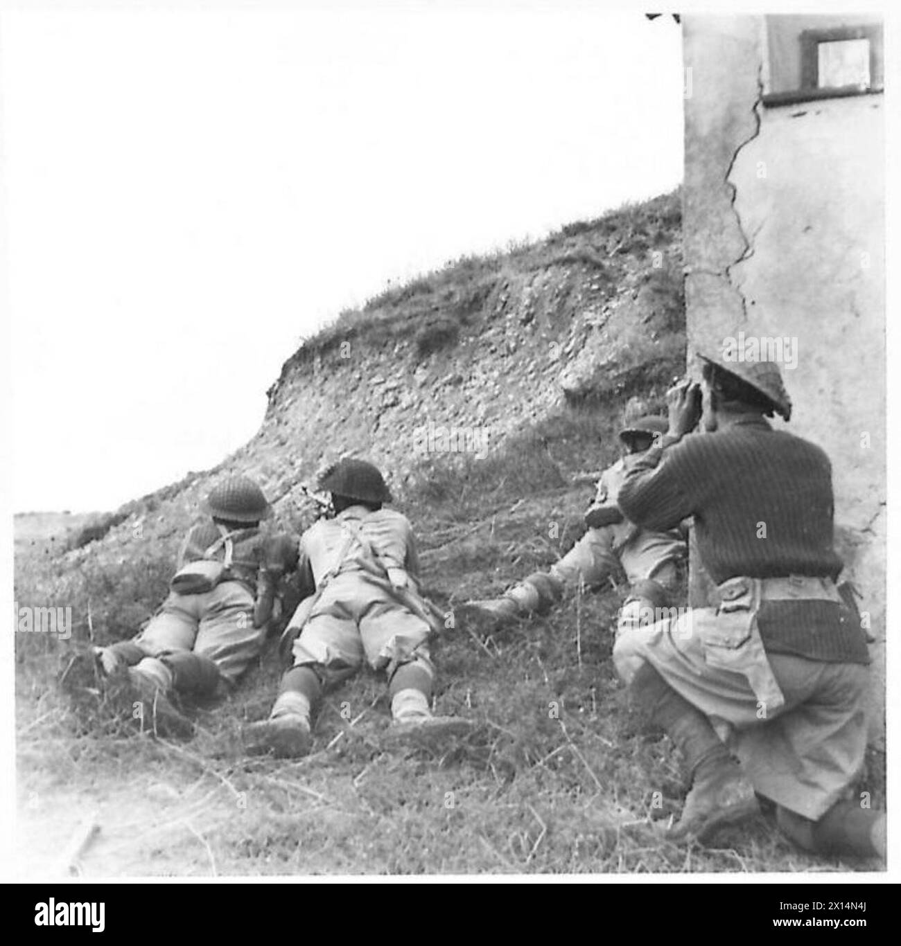 La patrouille Gurkha de la 8e armée avance sous la garde de tireurs et de mitrailleurs Bren ; l'officier observe les positions ennemies Banque D'Images