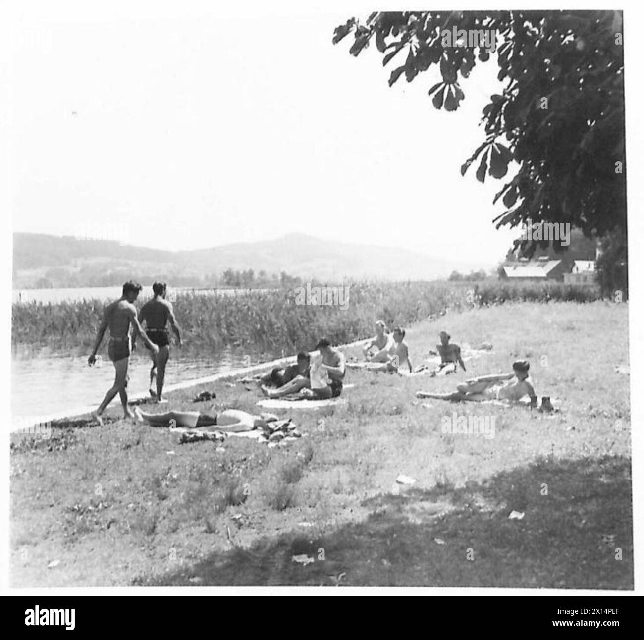 Le personnel de l'armée britannique en Autriche est montré relaxant et bronzant tandis que certains se baignent dans un lac pendant les loisirs. Banque D'Images