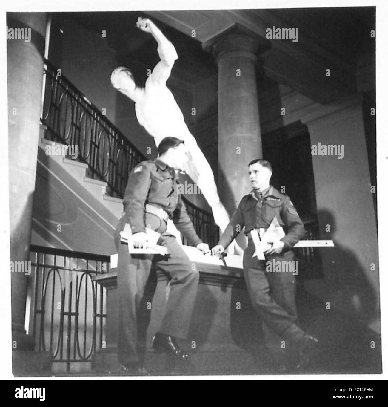 Le sapeur J.A. Cook et le sergent E. Burke étudient les arts, l'artisanat, l'histoire moderne et la vente au College of the Rhin de l'armée britannique du Rhin, après une expérience antérieure dans la maçonnerie et le commerce des peaux, interagissant près de la statue du lanceur de disques. Banque D'Images