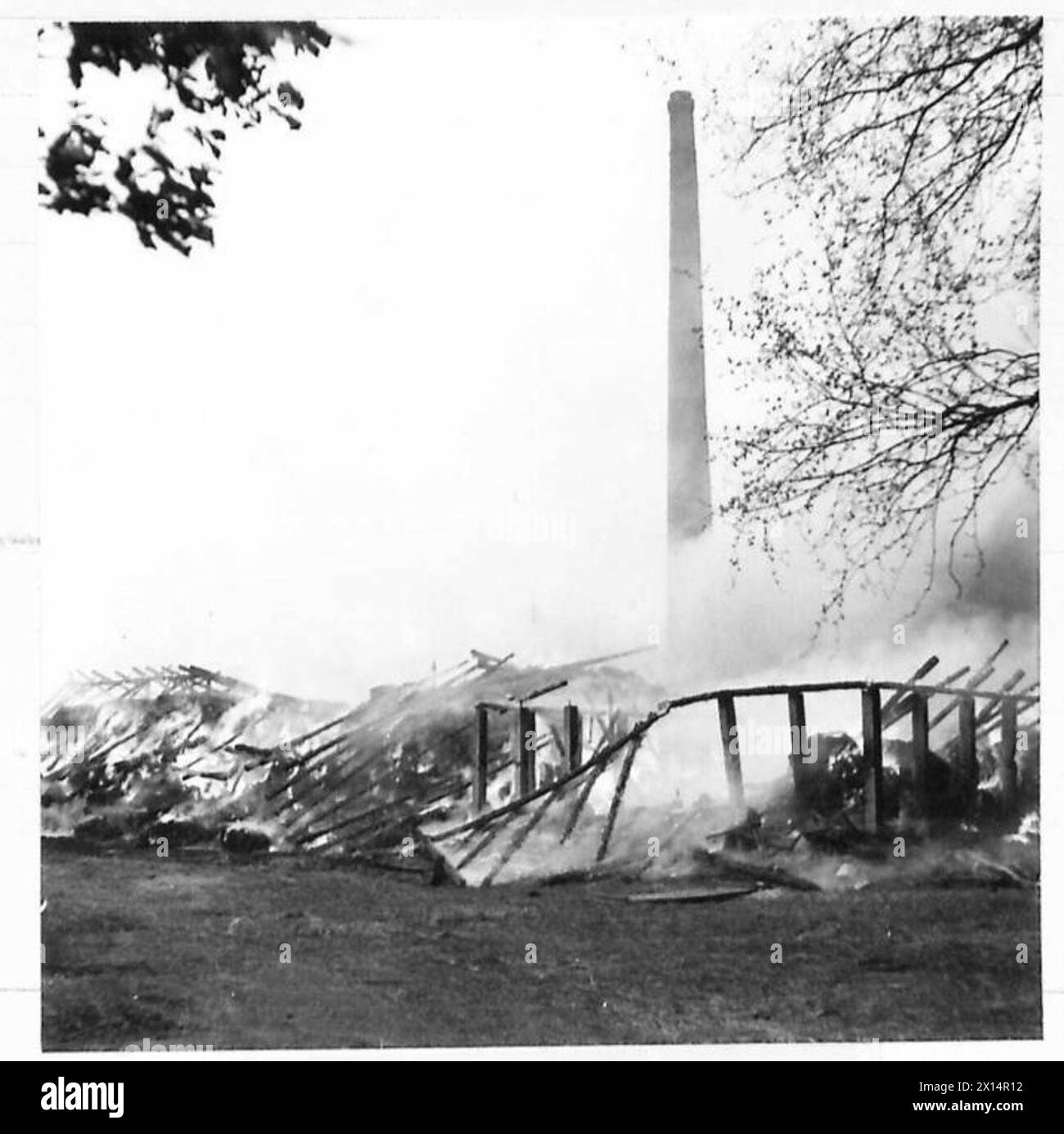 Les photographies montrent une usine flamboyante avec des véhicules de transport britanniques au premier plan pendant l'avance à travers l'Allemagne sous la supervision de l'armée britannique, du 21e groupe d'armées. Banque D'Images