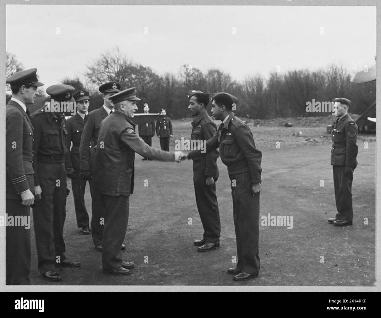 LE SPINNER DU LANCASHIRE PRÉSENTE SPITFIRE 'ETHEL MARSDEN' À LA ROYAL AIR FORCE. - Un Spitfire nommé 'Ethel Marsden', présenté à l'escadron de Bombay par Mr. Marsden, un spinner du Lancashire, a été officiellement remis à la R.A.F. par Sir Hugh Garrett, ancien secrétaire en chef du gouverneur de Bombay, et gouverneur par intérim du Sind en 1938. Photo (publiée en 1944) montre - Sir Hugh Garrett, portant l'uniforme de la Home Guard, salue deux pilotes de l'escadron de Bombay. Il serre la main de l'officier volant A.O. Weeks, de la Royal Air Force des Antilles britanniques Banque D'Images