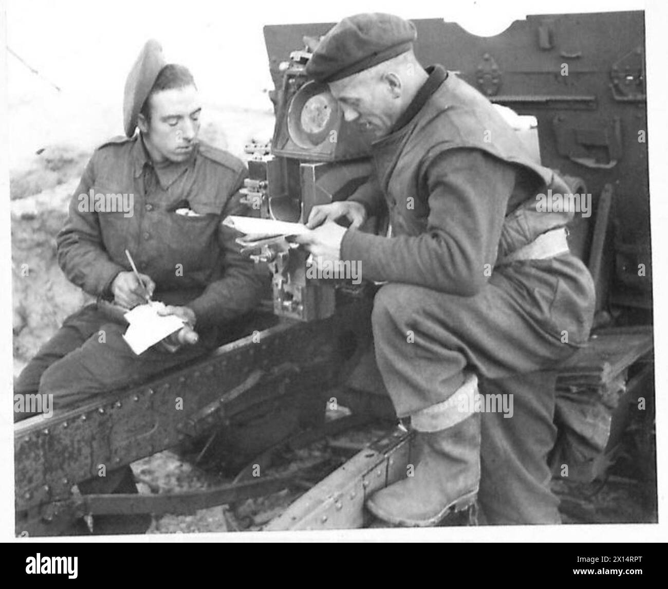 Le Gunner D. Sirrel écrit un message sur un feuillet de propagande tandis que le Gunner A. Cropper vérifie les cartes avant un tir de feuillet PDR en 25, 21e Groupe d'armées. Banque D'Images