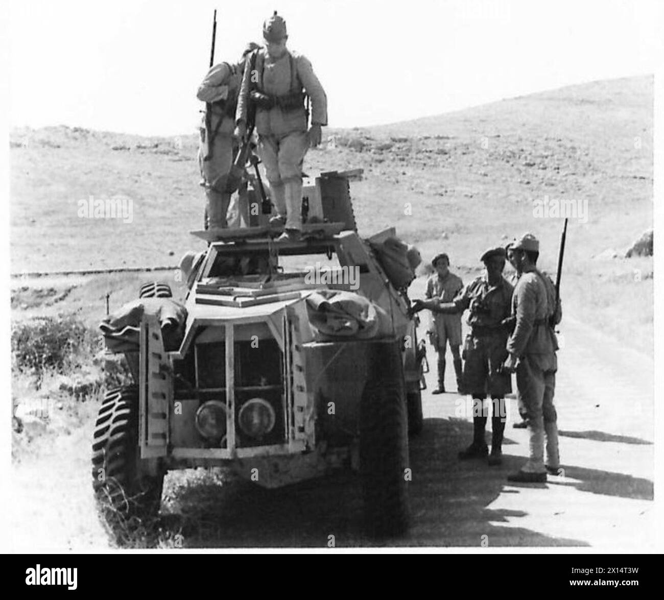Des soldats turcs observent un véhicule blindé utilisé pour patrouiller la frontière pendant l'occupation de la Syrie par les forces militaires de l'armée britannique. Banque D'Images