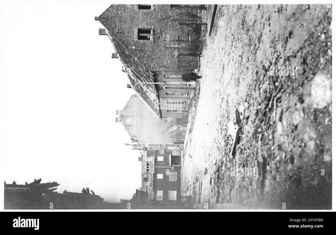 La ville de Blerick montre des rues désertes et des maisons endommagées, reflétant l'impact des opérations militaires. La scène est documentée par l'armée britannique, 21e groupe d'armées. Banque D'Images