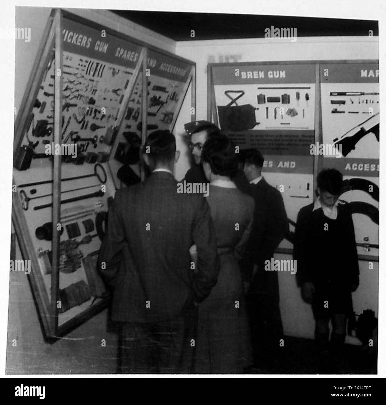 Les visiteurs inspectent les pièces de rechange et les accessoires des armes à feu Vickers lors d'une exposition d'équipement de l'armée britannique. Banque D'Images