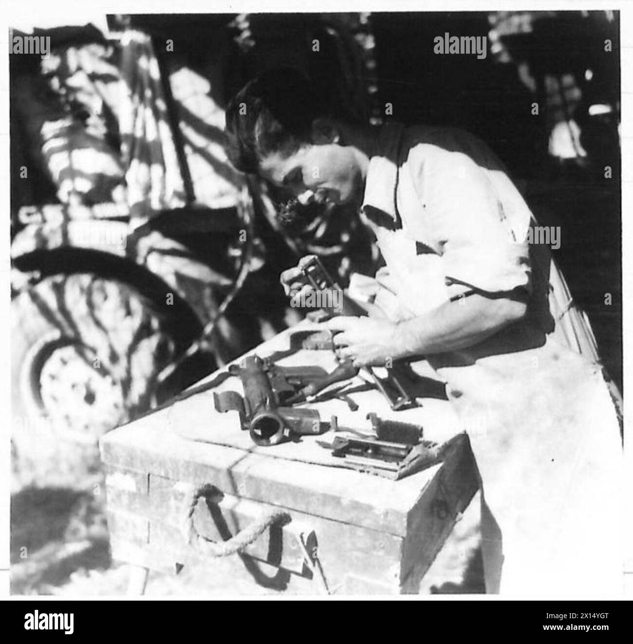 Le sergent N. Capsalis des ingénieurs électriciens et mécaniciens royaux grecs (REME) effectue des réparations sur une arme automatique dans un atelier pendant les opérations de la 8e Armée. Banque D'Images