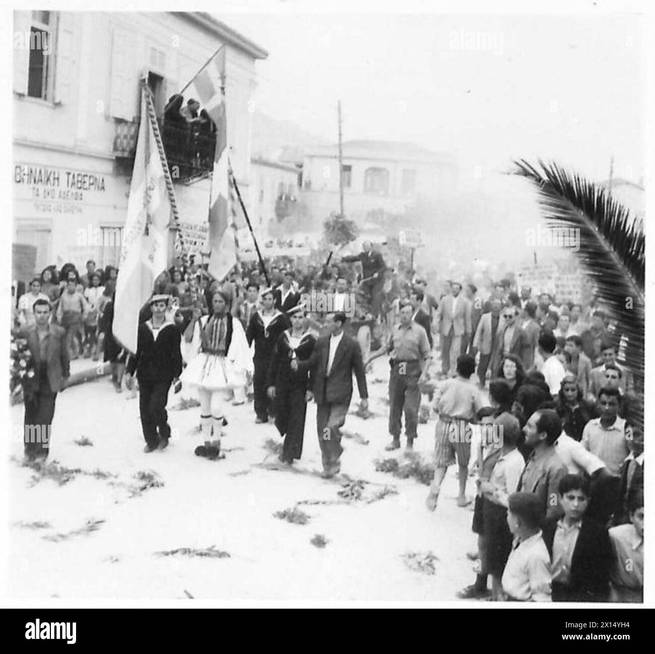 Les troupes britanniques entrant dans Xilokastron, en Grèce, sont accueillies par un cortège dirigé par un grec en costume national lors de l'avance vers Corinthe. Banque D'Images
