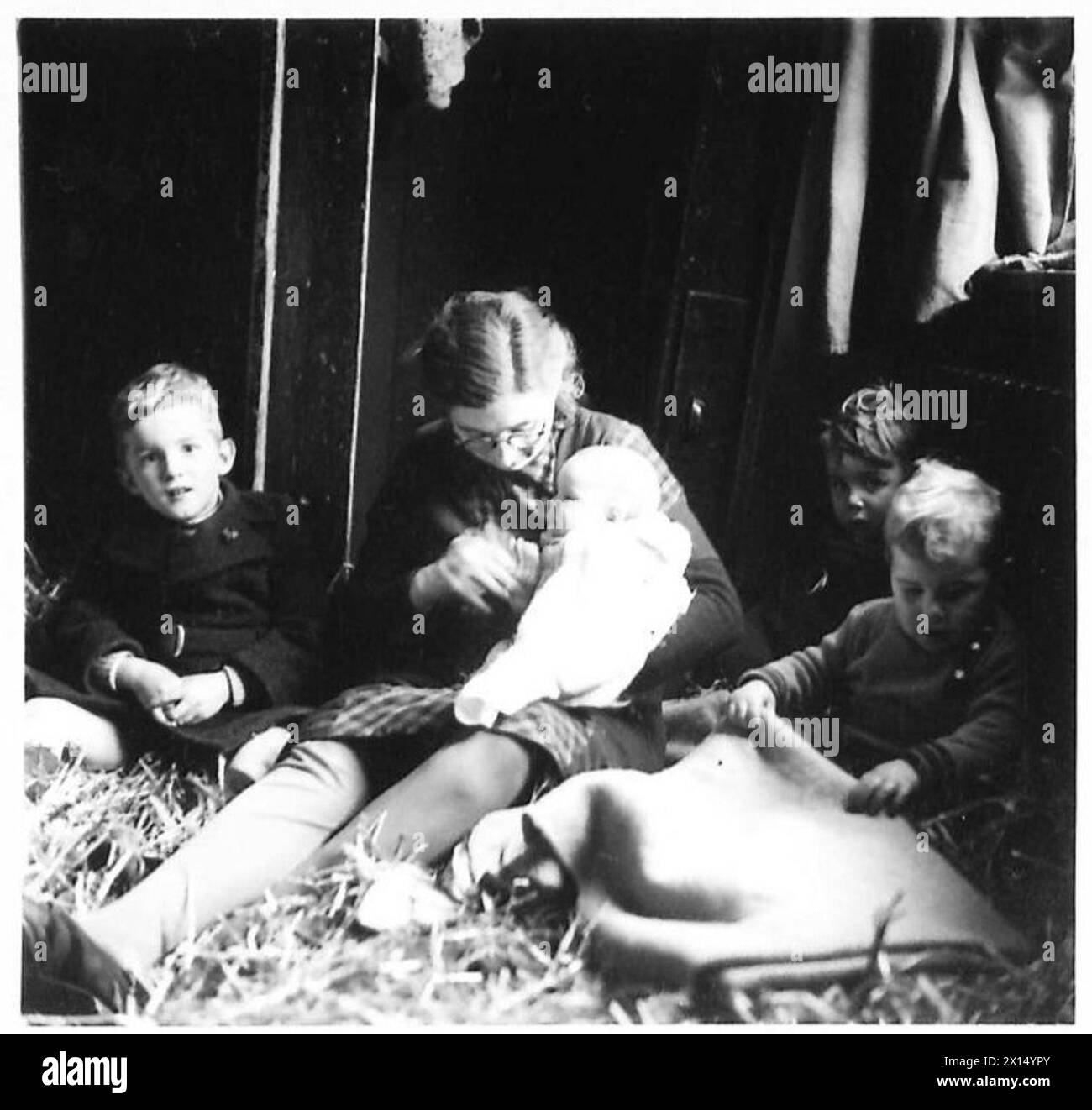 Une femme et ses quatre enfants de Blerick se mettent à l'aise sur une literie de paille tout en recevant l'aide des opérations de l'armée britannique sous le 21e groupe d'armées. Banque D'Images