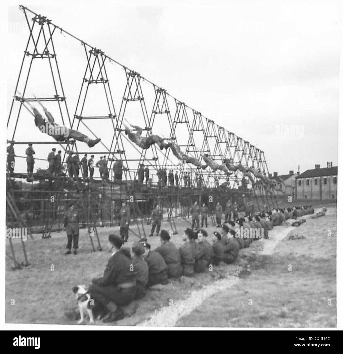 Les volontaires du Parachute Training Depot et de l'école pratiquent le contrôle aérien sur des appareils de trapèze tandis que d'autres troupes aéroportées observent et attendent leur tour, opérées par l'armée britannique. Banque D'Images Les volontaires du Parachute Training Depot et de l'école pratiquent le contrôle aérien sur des appareils de trapèze tandis que d'autres troupes aéroportées observent et attendent leur tour, opérées par l'armée britannique. Banque D'Images