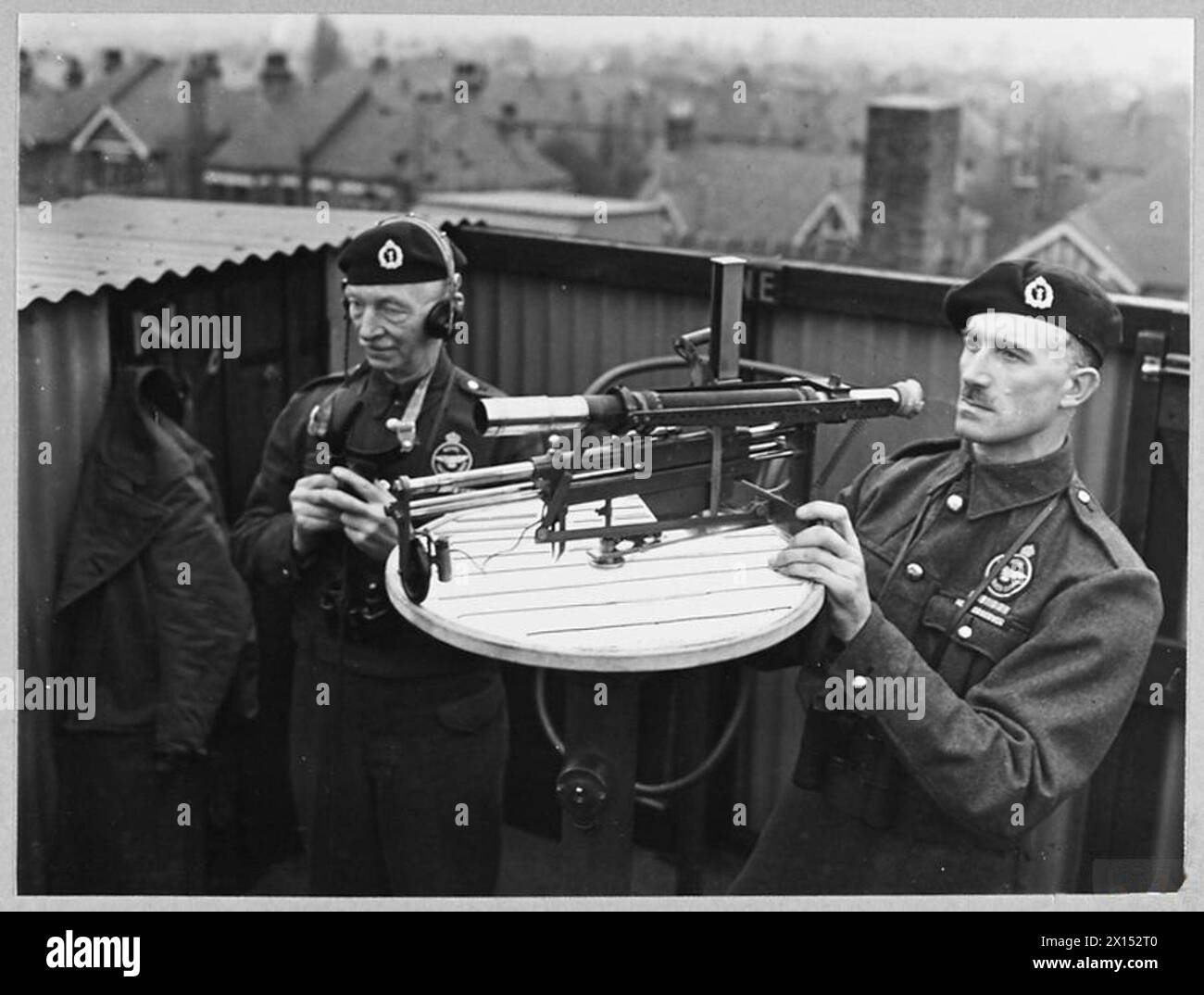 L'observateur en chef W.H. Smith observe un avion à travers un télescope tandis que le capitaine A.H. Silvester transmet des informations par téléphone à un poste national du Royal observer corps, la Royal Air Force. Banque D'Images