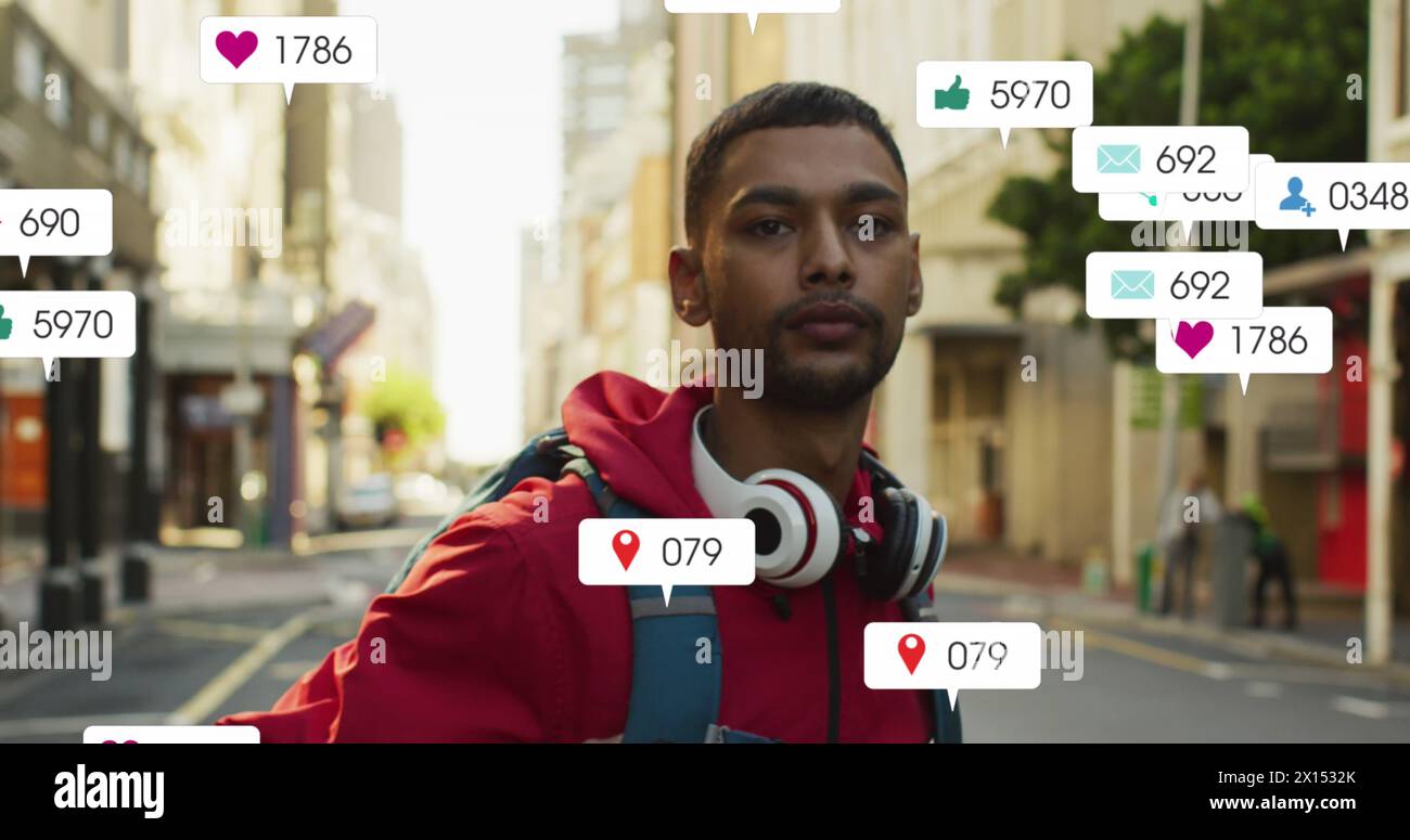 Image de numéros changeants, icônes dans les barres de notification sur l'homme biracial debout dans la rue Banque D'Images