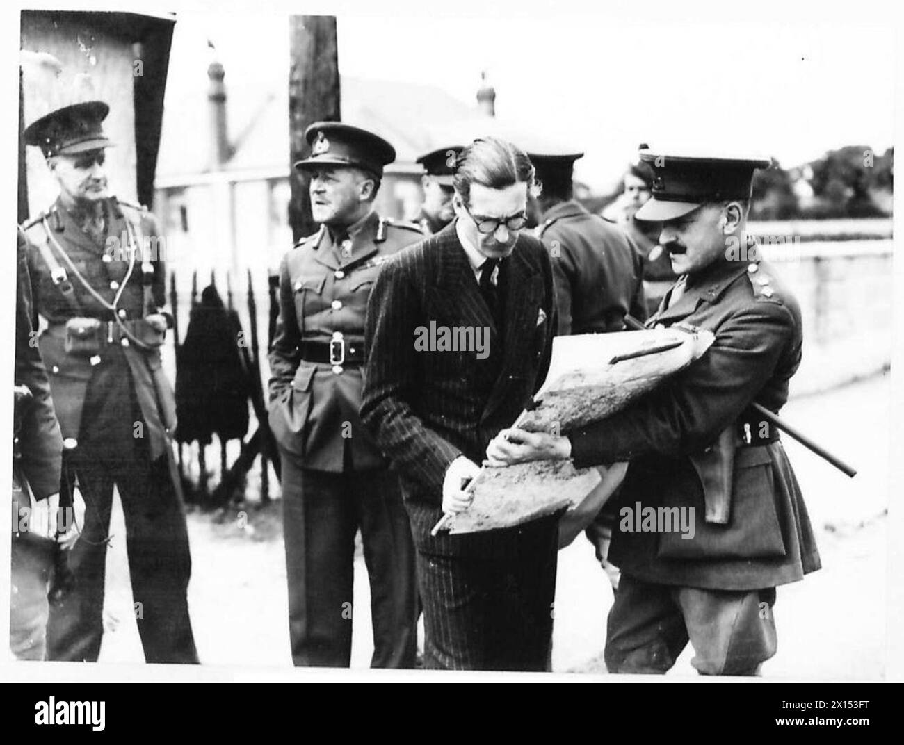 LE SECRÉTAIRE D'ÉTAT VISITE LES DÉFENSES CÔTIÈRES - Mr. A. Eden étudie une carte de la ligne fortifiée de l'armée britannique Banque D'Images