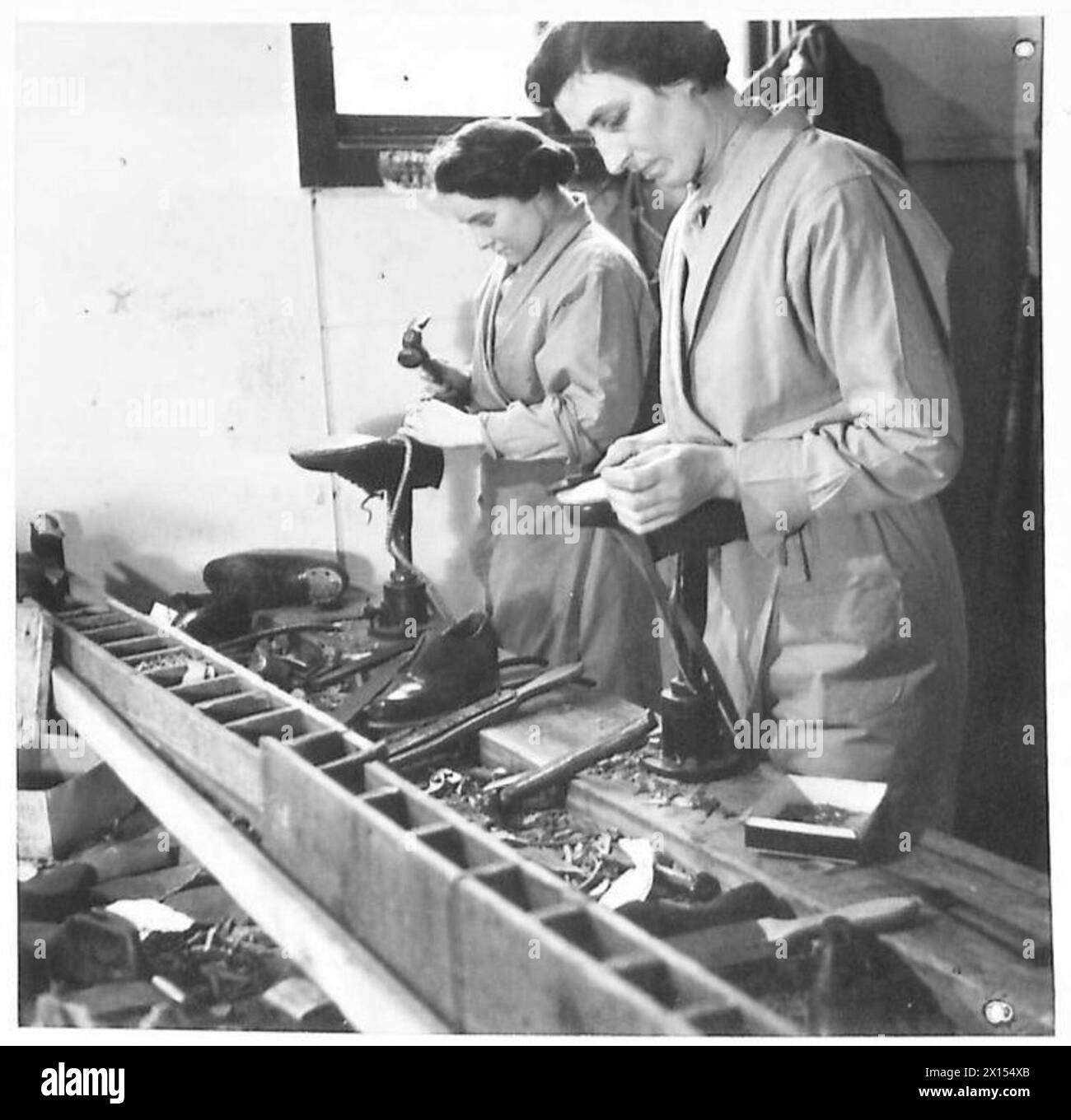 Négatif - cordonniers ATS au travail. Pte. Millicent War (le plus grand des deux) rejoint l'ATS en décembre 1941. Le Sdt Doreen lever a connu trois ans de service. On les voit travailler sur le banc de bottes réparant des chaussures de l'armée britannique Banque D'Images