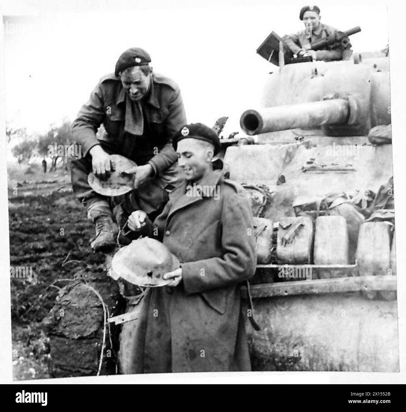Les troupes E. Mossman d'Édimbourg et E. B. Smith de Stoke-on-Trent inspectent leurs casques après avoir subi des coups d'éclats lors de tirs de mortier dans la région d'Ortona-Orsogna. Les deux font partie des opérations de la 8e armée britannique en Italie. Banque D'Images