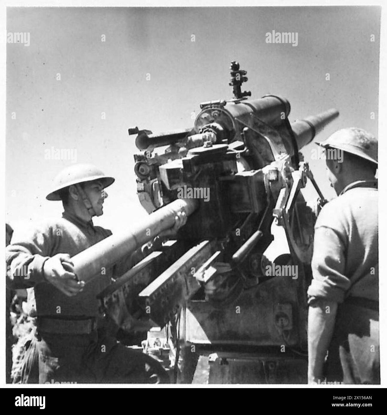 AVEC LA HUITIÈME ARMÉE (DIVERS) - Un régiment de l'artillerie royale (rattaché à la division néo-zélandaise) a capturé plusieurs canons allemands de 88 mm et ils sont maintenant utilisés contre l'ennemi. Ces canons peuvent être utilisés pour les tirs anti-chars, de terrain et anti-aériens. Les canons sont montrés au combat à Enfideville, au nord de l'armée britannique de Sousse Banque D'Images