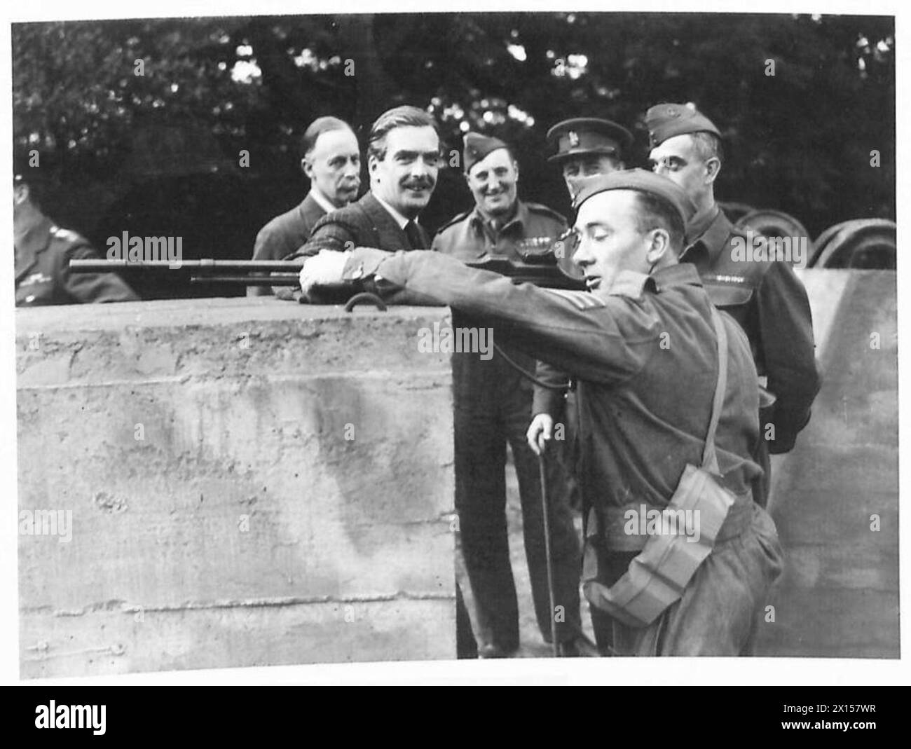 Le secrétaire d'État à la Guerre Anthony Eden observe un sergent manœuvrant un barrage routier avec un fusil automatique Browning lors d'une visite à une unité de la Home Guard. Banque D'Images
