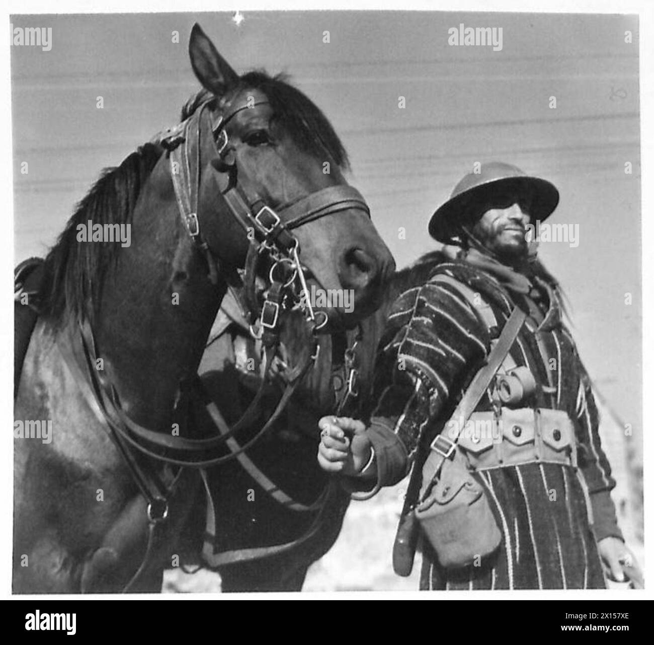 Un soldat Goumier du Maroc, debout avec son chargeur arabe et vêtu d'un burneux, attend son officier français. Goumiers, comparable à Ghurkas, a servi dans les campagnes de montagne en Tunisie et en Italie avec l'armée britannique de 1942 à 1946. Banque D'Images