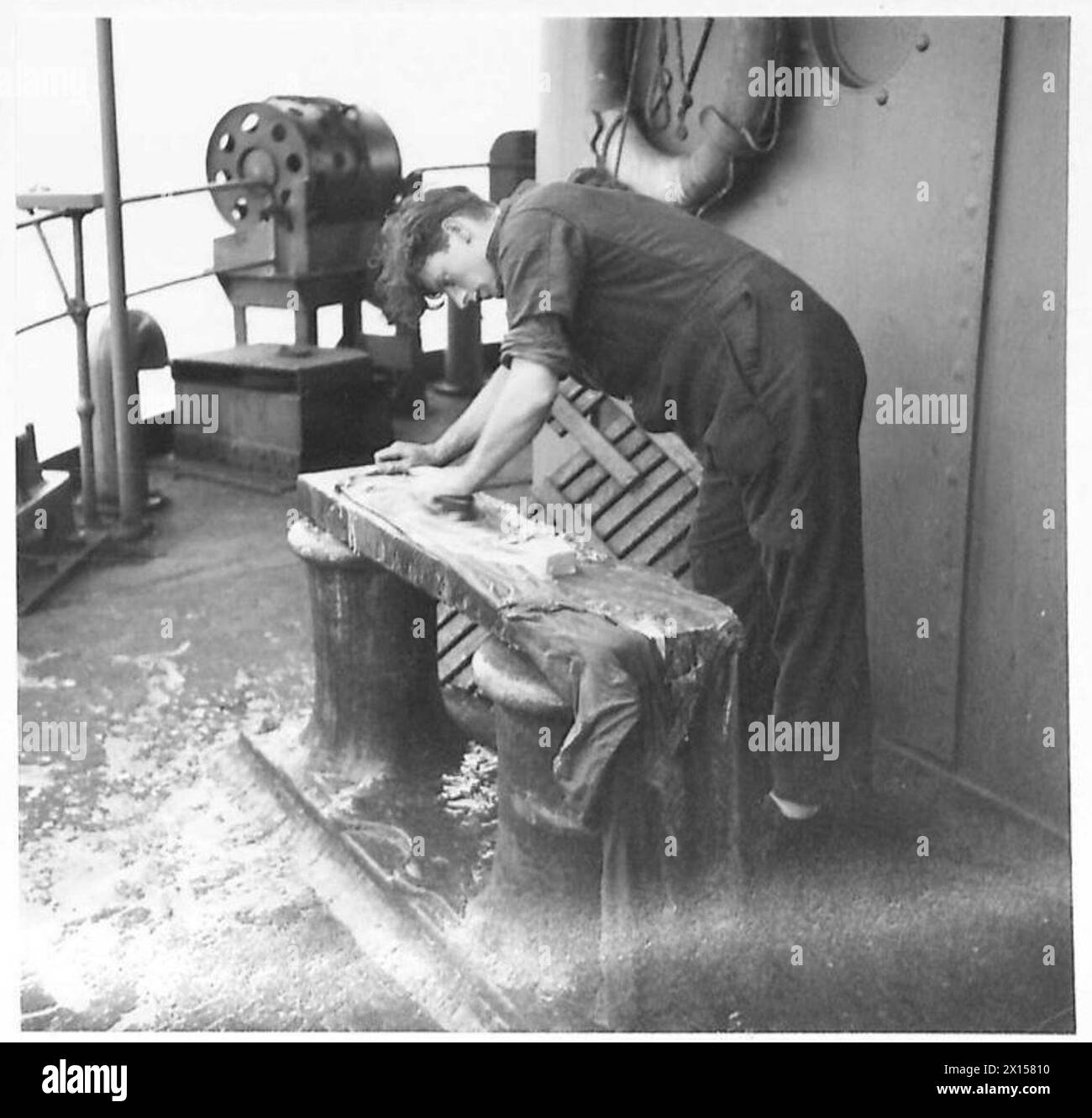 L. Gillian de Stepney, Londres, frotte ses propres vêtements à bord d'un petit navire dans un convoi vers l'Afrique sous la supervision de l'armée britannique. Banque D'Images