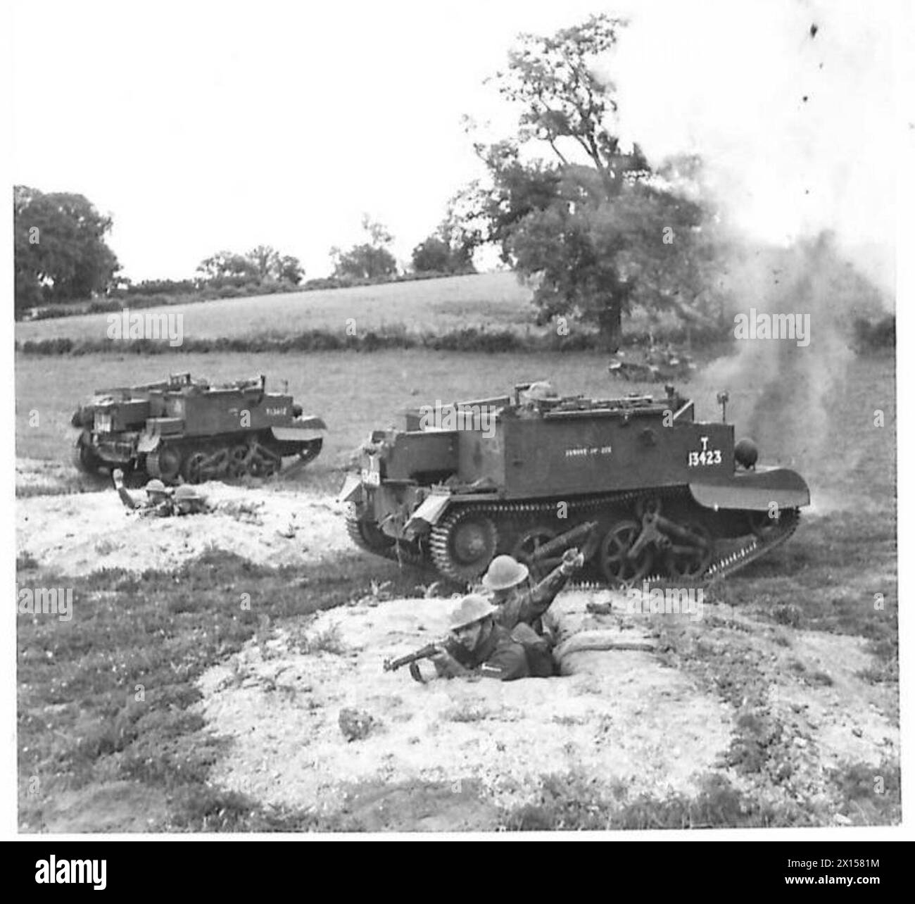 Les hommes du Royal Berkshire Regiment mènent des exercices de renforcement, en utilisant des tranchées fendues et en engageant des porte-avions Bren avec des tirs de fusil et des grenades lors d'une fausse bataille. Banque D'Images