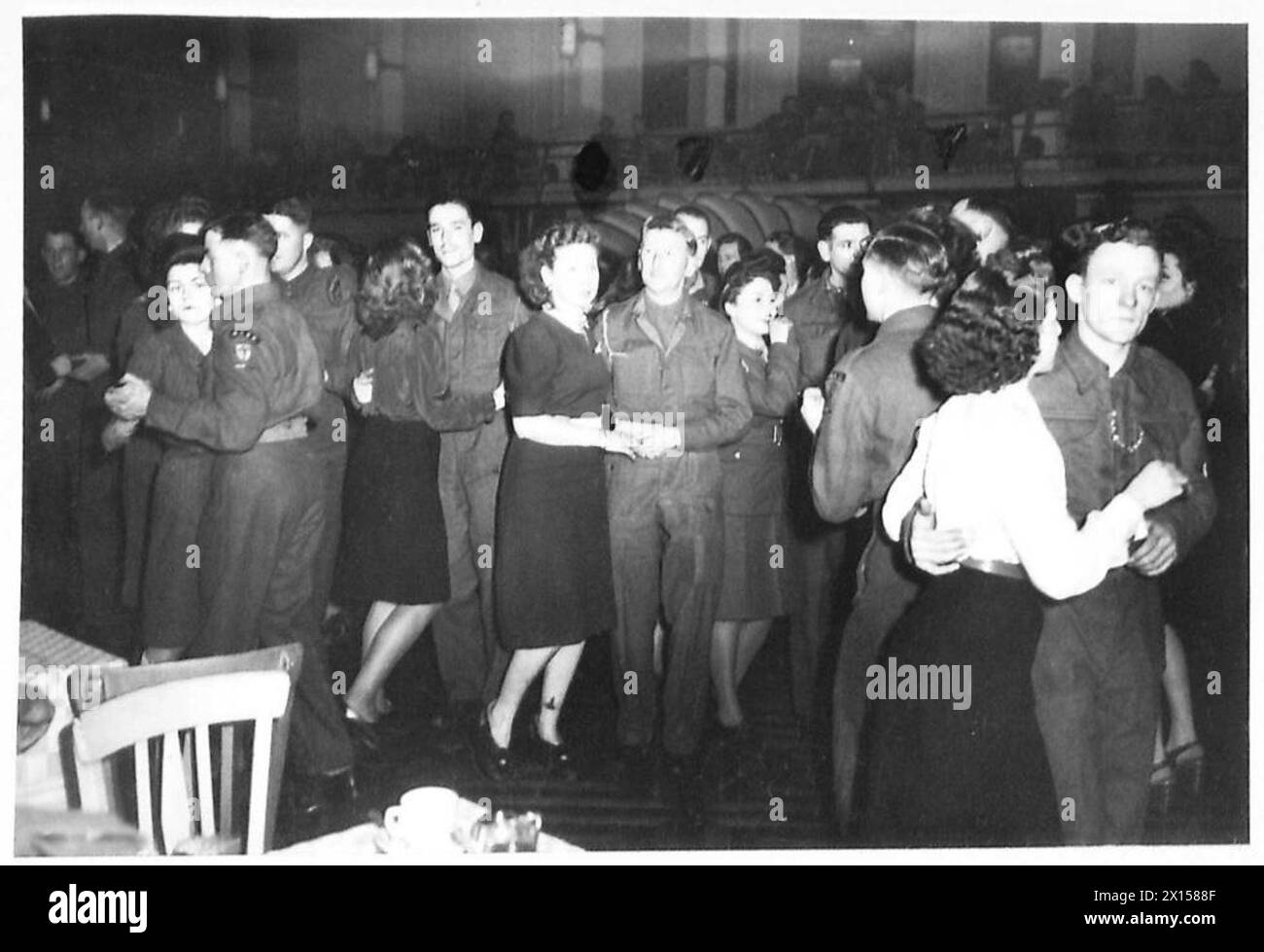 Les filles de service interagissent avec des mécènes masculins au 21 Dance Club de Bruxelles, où la danse jitterbug est populaire parmi les Belges malgré la désapprobation allemande en temps de guerre. Banque D'Images