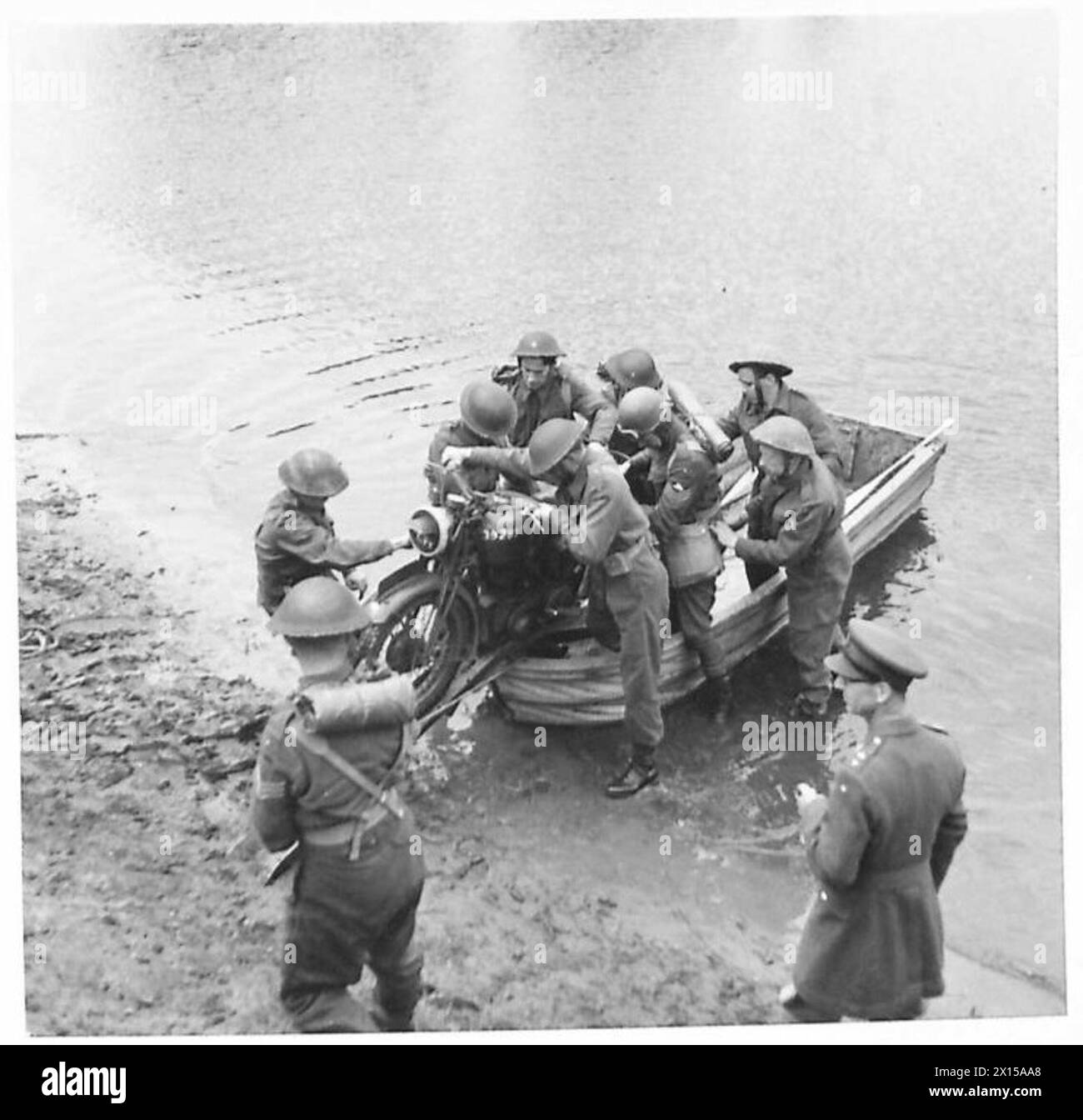 Un groupe de sapeurs atteint la rive opposée d'une rivière et se tient prêt à transporter une moto d'un bateau d'assaut dans le cadre des opérations militaires de traversée de rivière. Banque D'Images